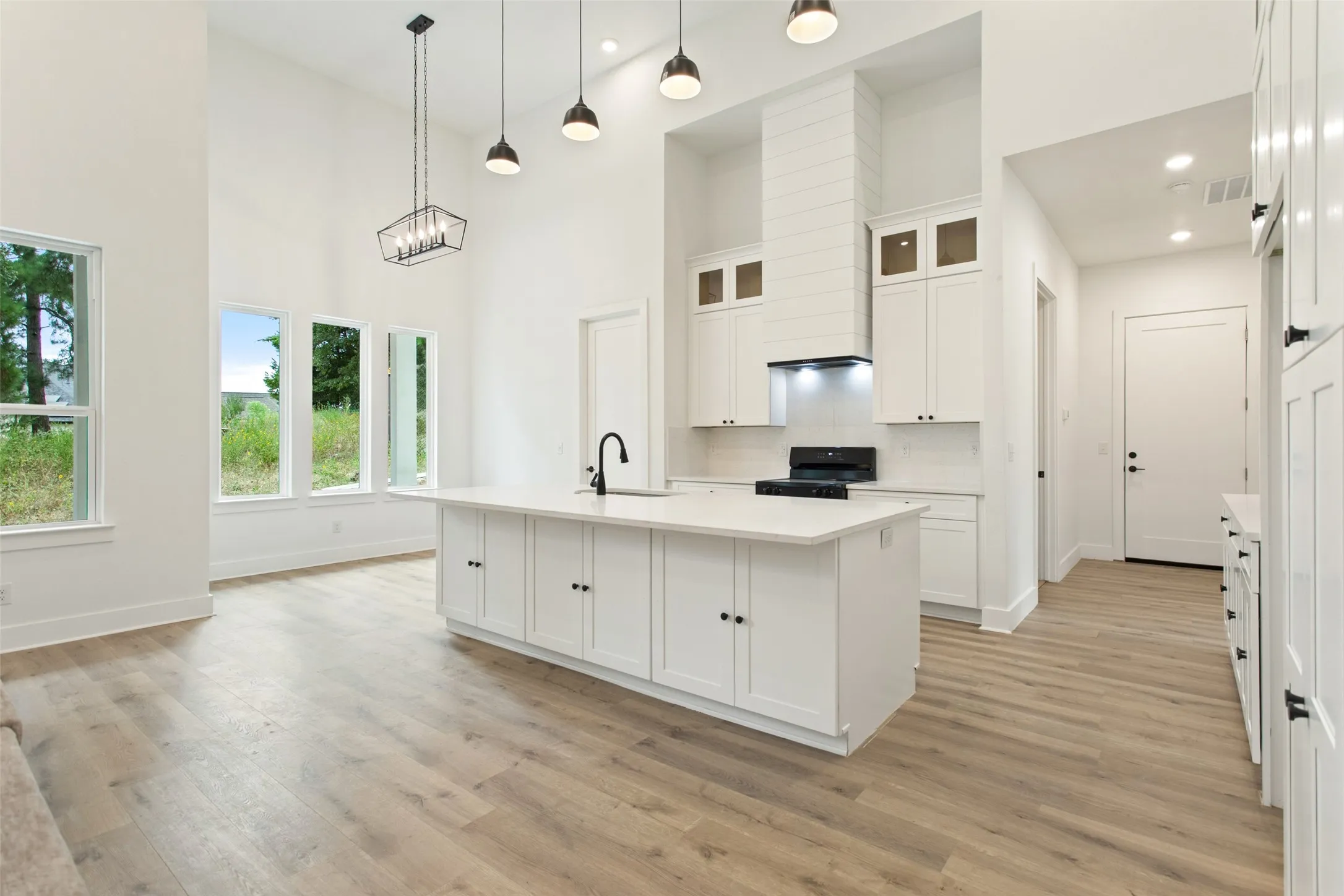 Vaulted ceilings with recessed lighting and pendant fixtures