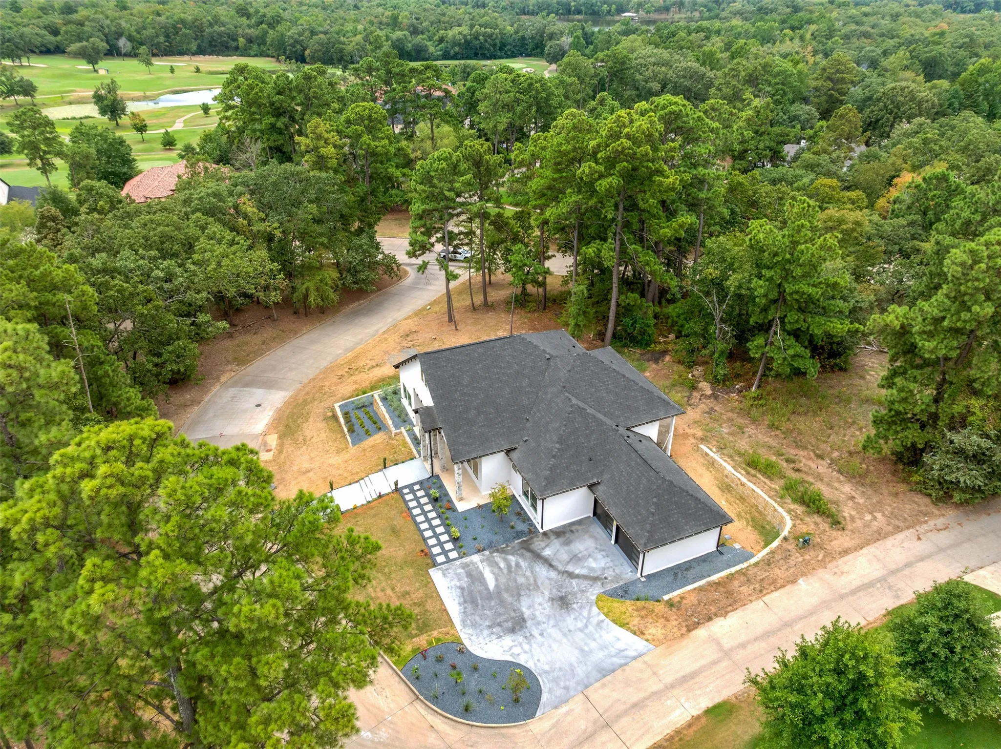Modern residence with a multi-pitched roofline, white exterior, and attached garage