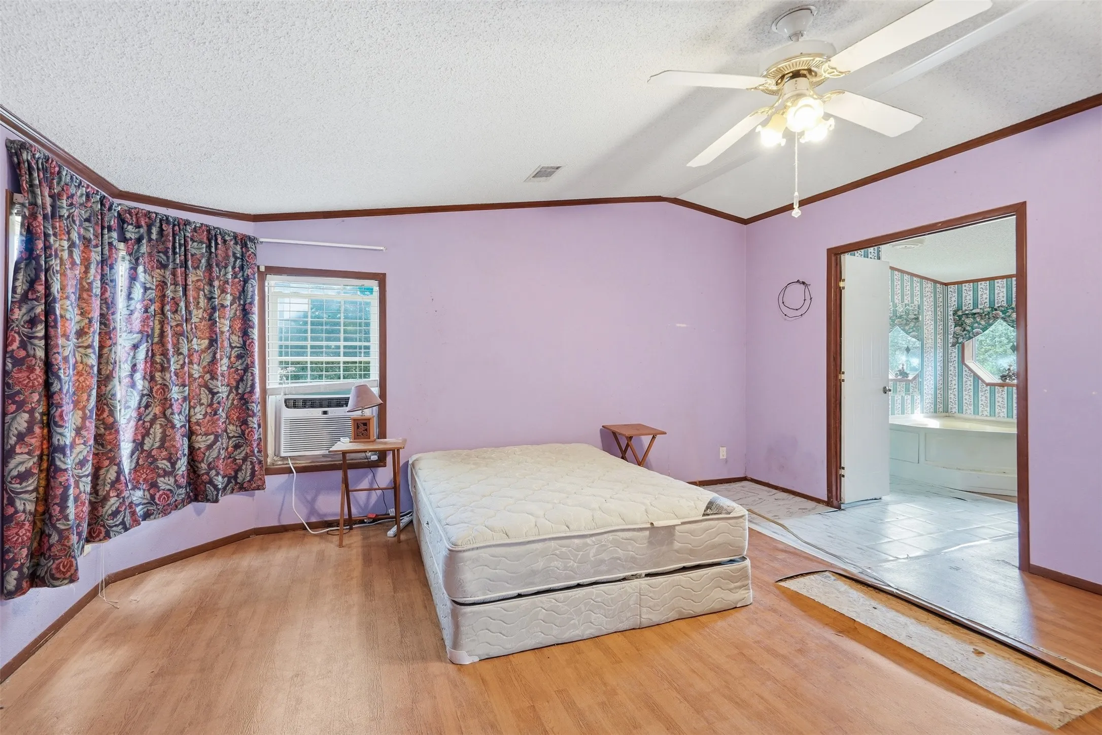 Wood-finish flooring, ceiling fan, and window-mounted air conditioning unit