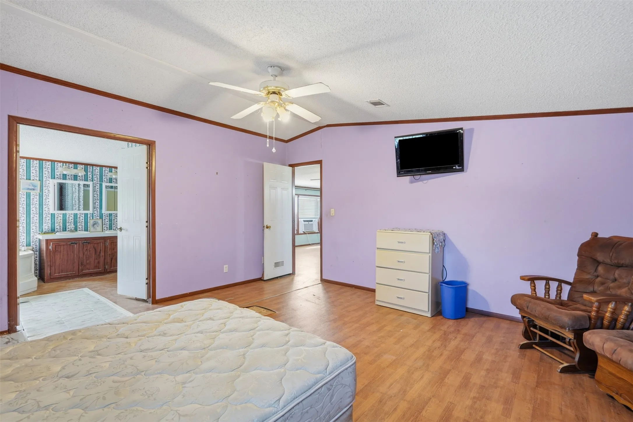 Wood-finish flooring throughout, ceiling fan, and multiple doorways