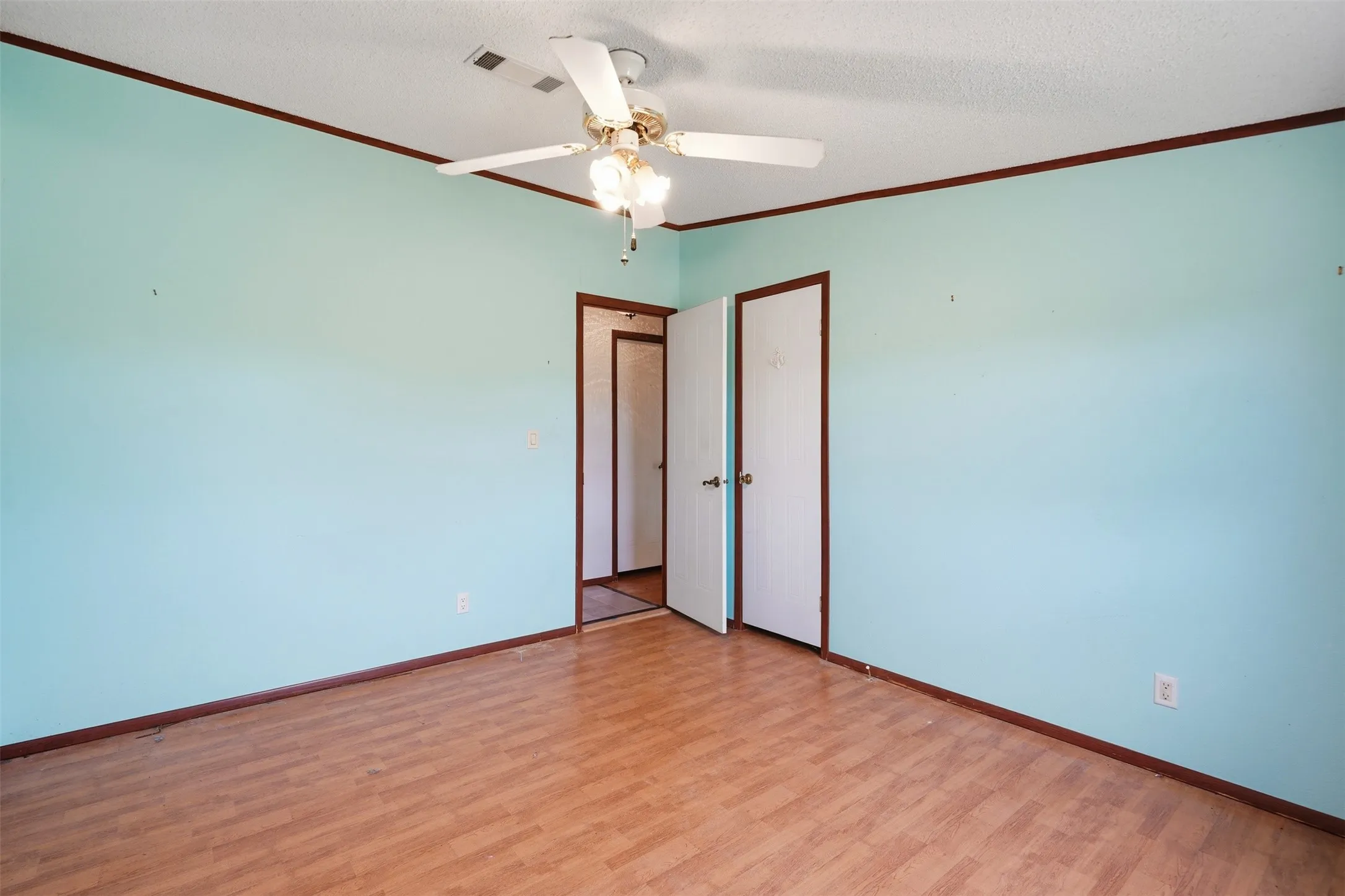 2nd bedroom - Wood-finish flooring, ceiling fan with light fixture, and two panel doors