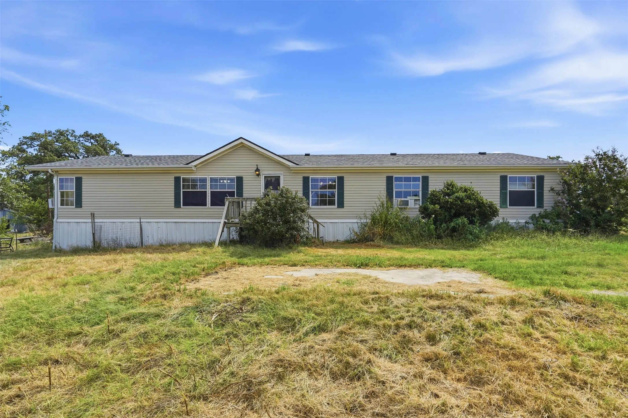 Spacious manufactured home featuring a neutral exterior with multiple windows, metal siding, and a covered front entry