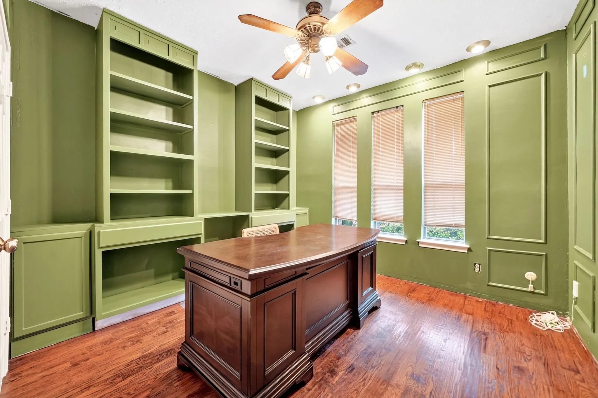 Hardwood-style flooring, built-in shelving, recessed lighting, and a ceiling fan with light