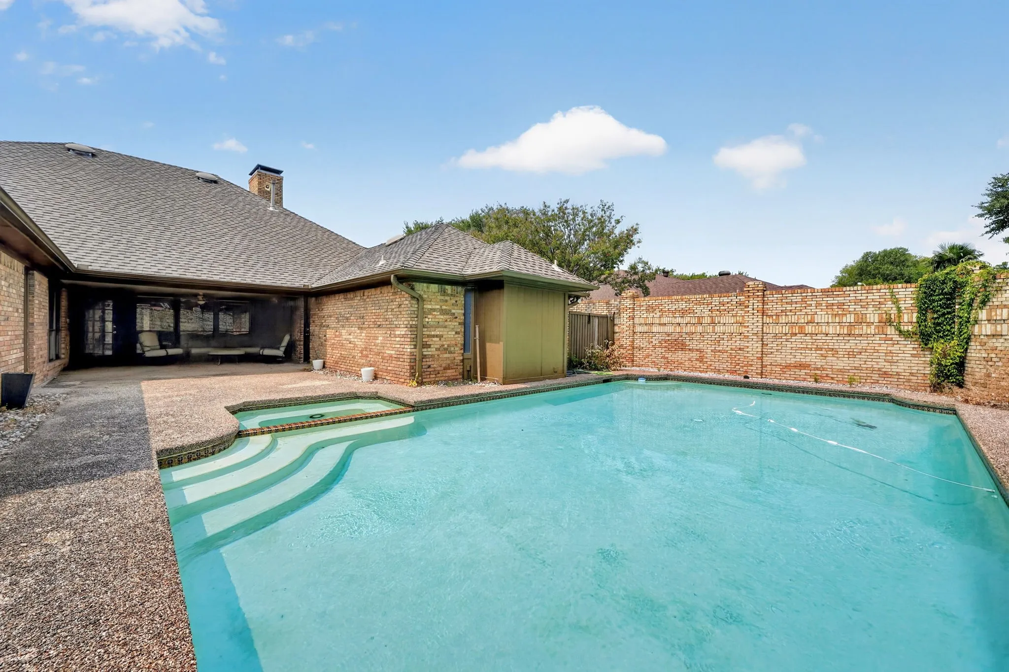 In-ground swimming pool with integrated spa and stepped entry