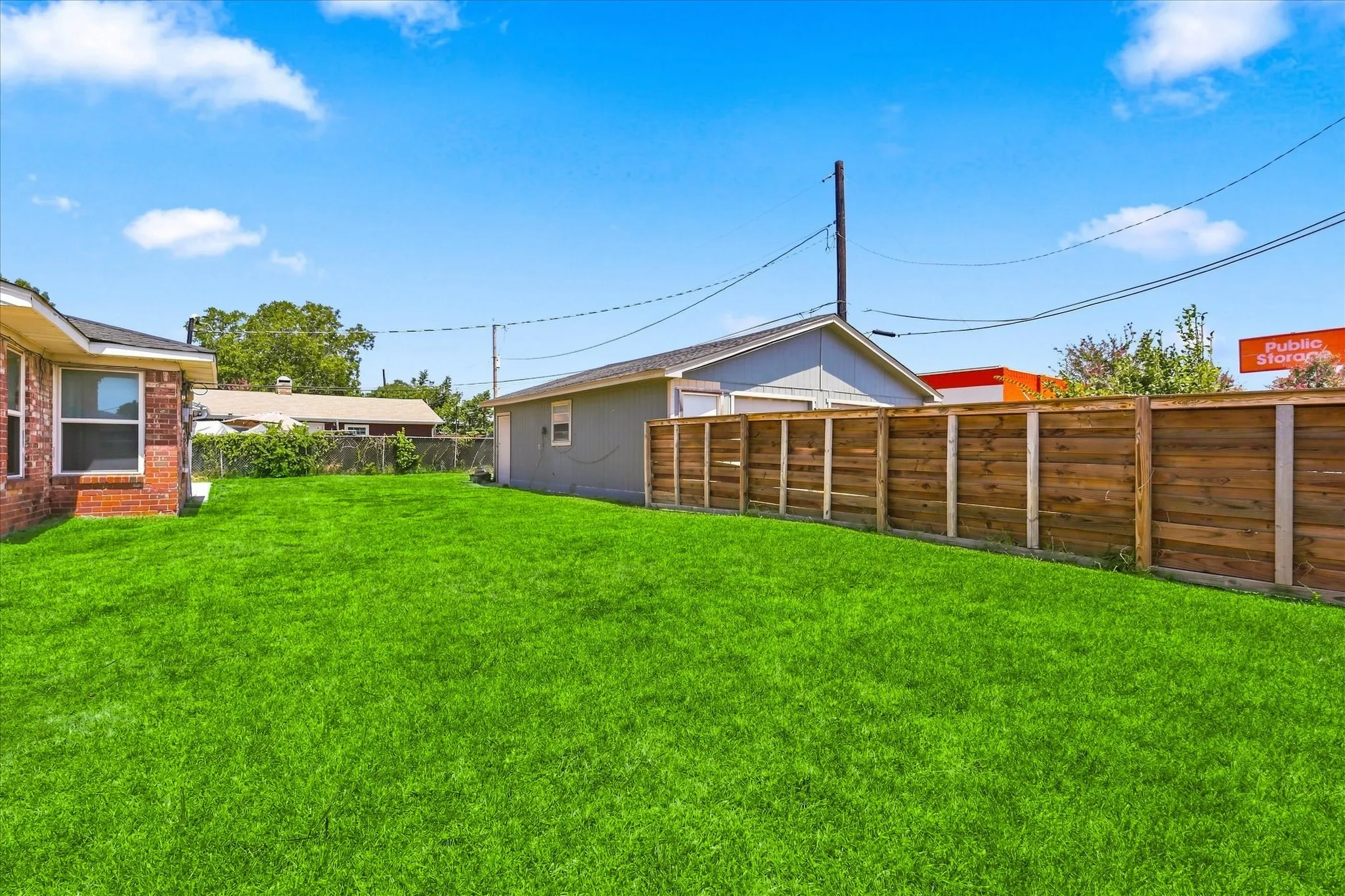 Expansive lawn area, wood panel fencing, and a detached structure