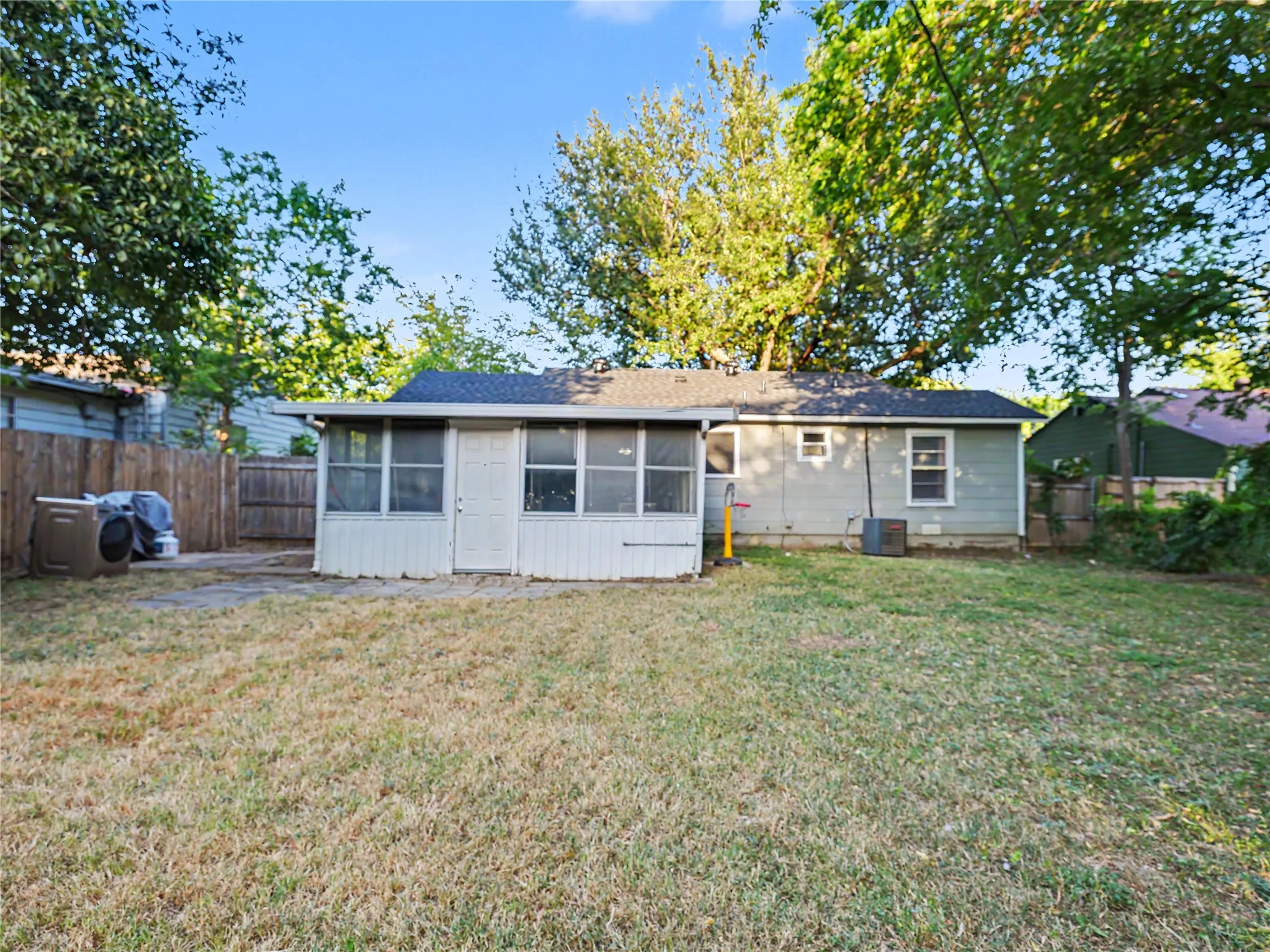 Expansive backyard with a wood privacy fence and mature trees