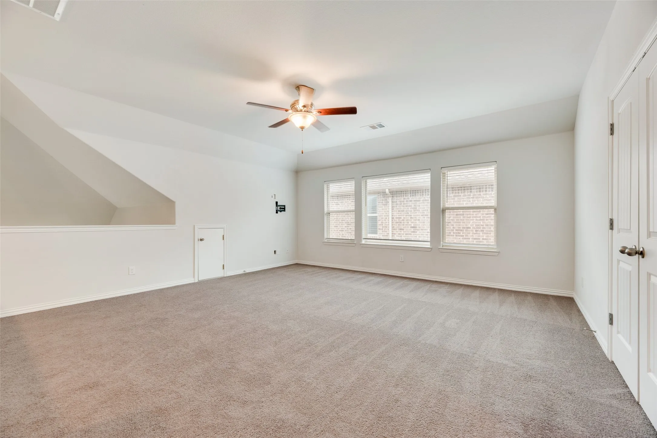 Unfurnished bedroom featuring baseboards, light carpet, a ceiling fan, and visible vents