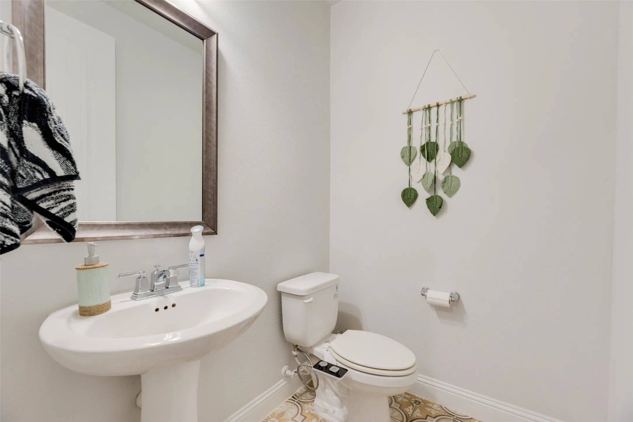 Bathroom with baseboards, a sink, tile patterned flooring, and toilet