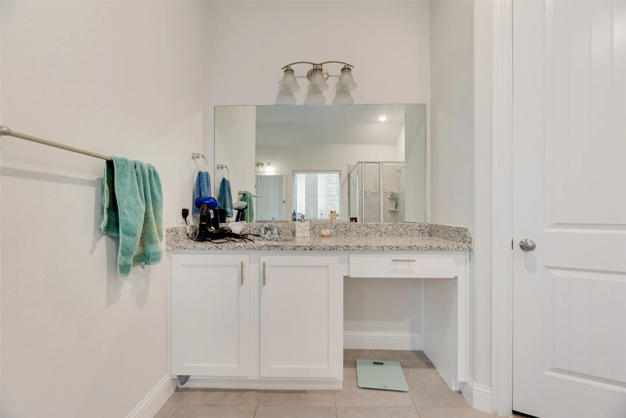 Bathroom with tile patterned flooring, baseboards, a stall shower, and vanity