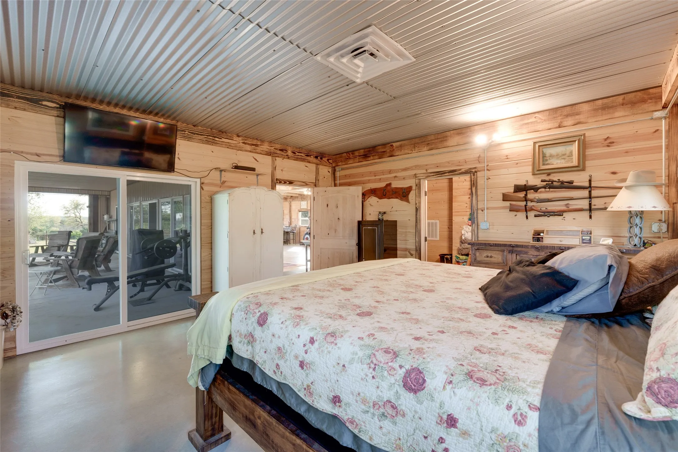 Corrugated metal ceiling, wood-finish walls, polished concrete flooring, sliding glass doors, recessed lighting
