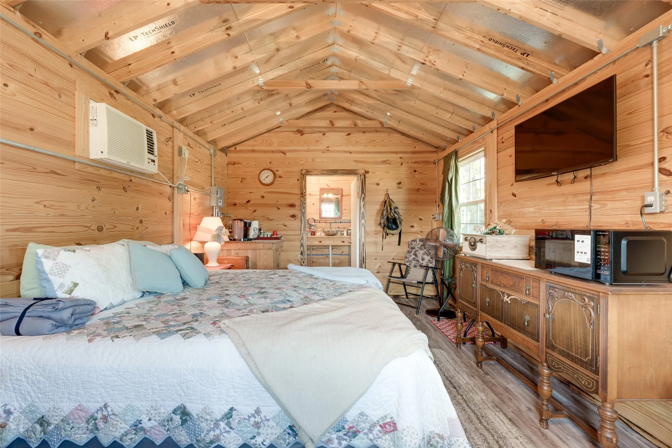 Wood-paneled interior with a vaulted ceiling and exposed beams