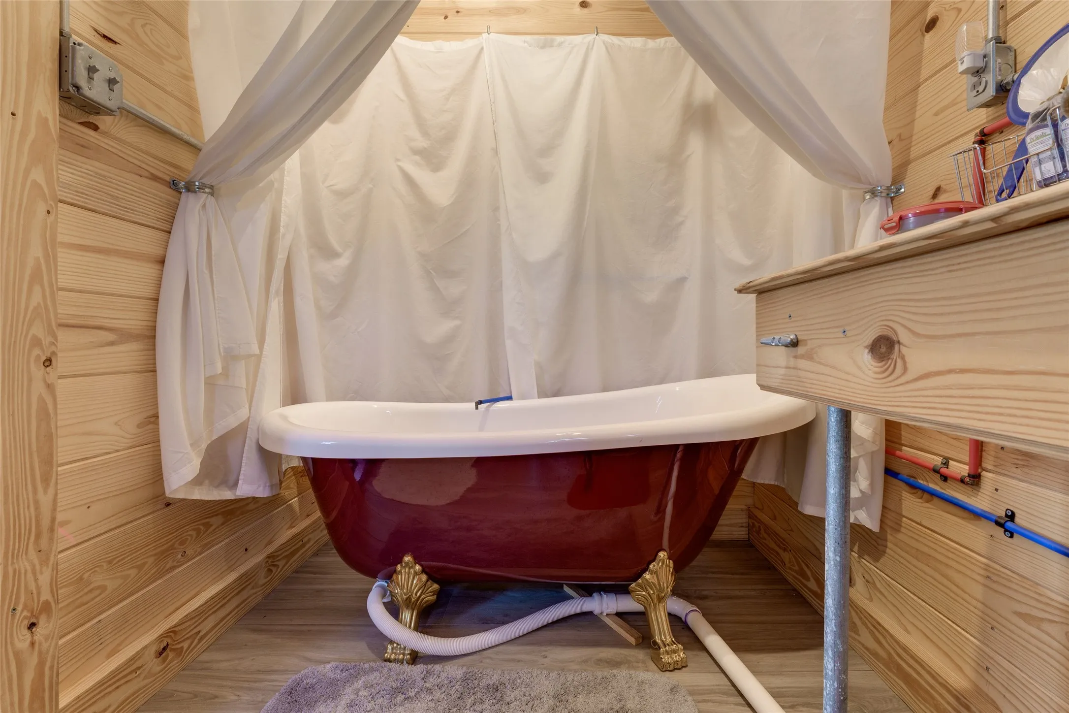Clawfoot bathtub with an ornate base and a wooden vanity featuring a vessel sink