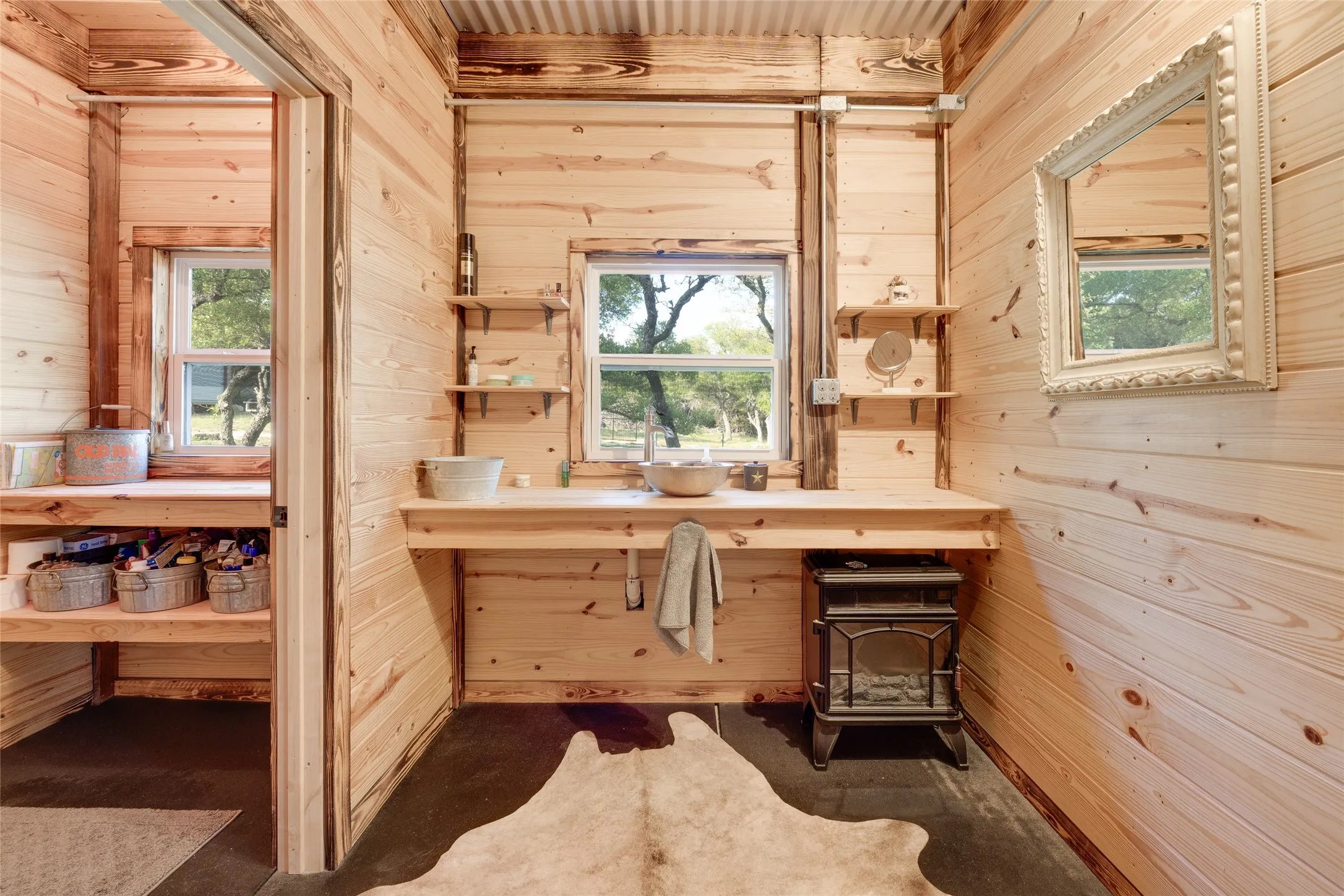 Wood-paneled interior with a built-in wood countertop, integrated sink, and exposed shelving