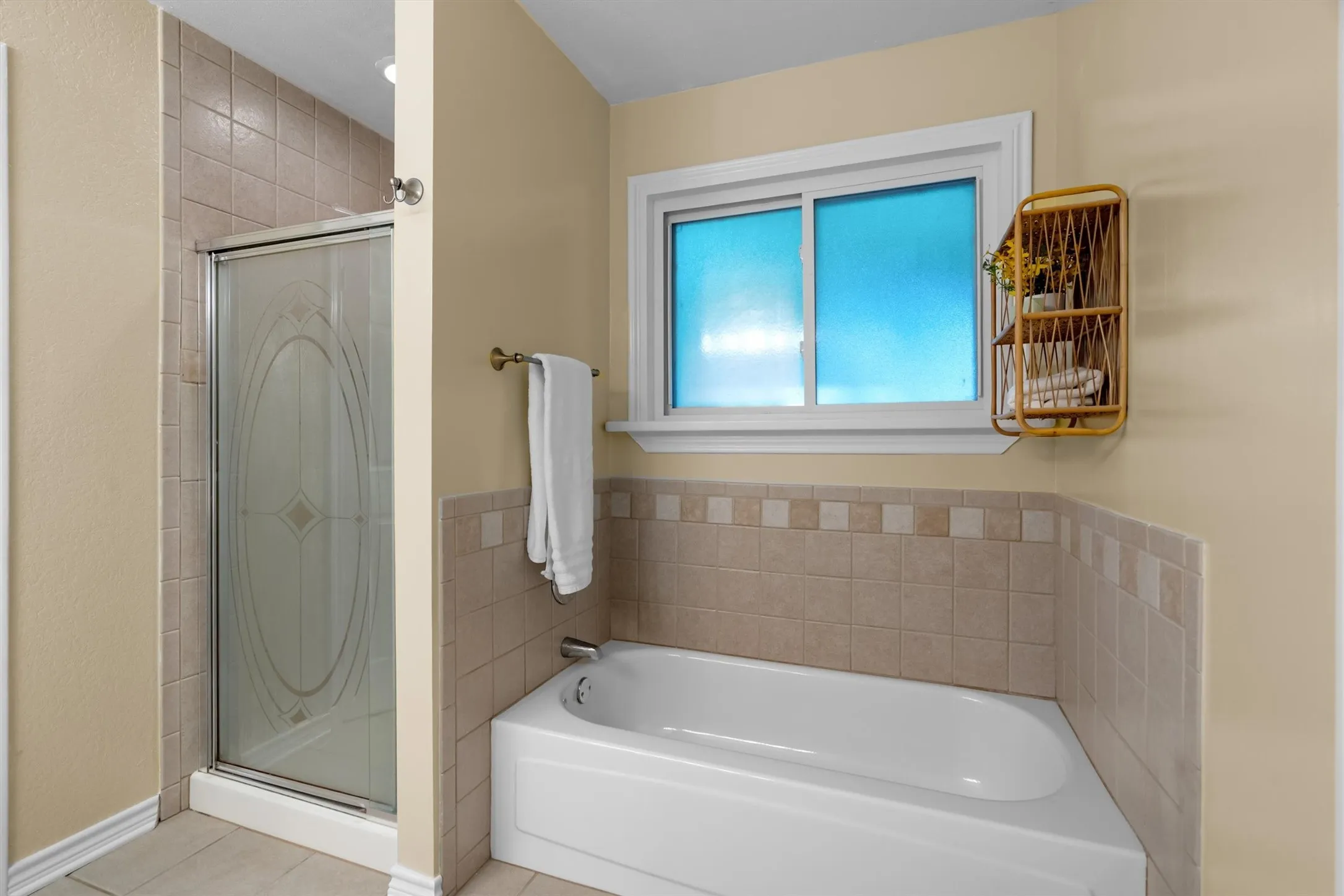 Primary bath detail featuring a glass-enclosed shower and deep soaking tub