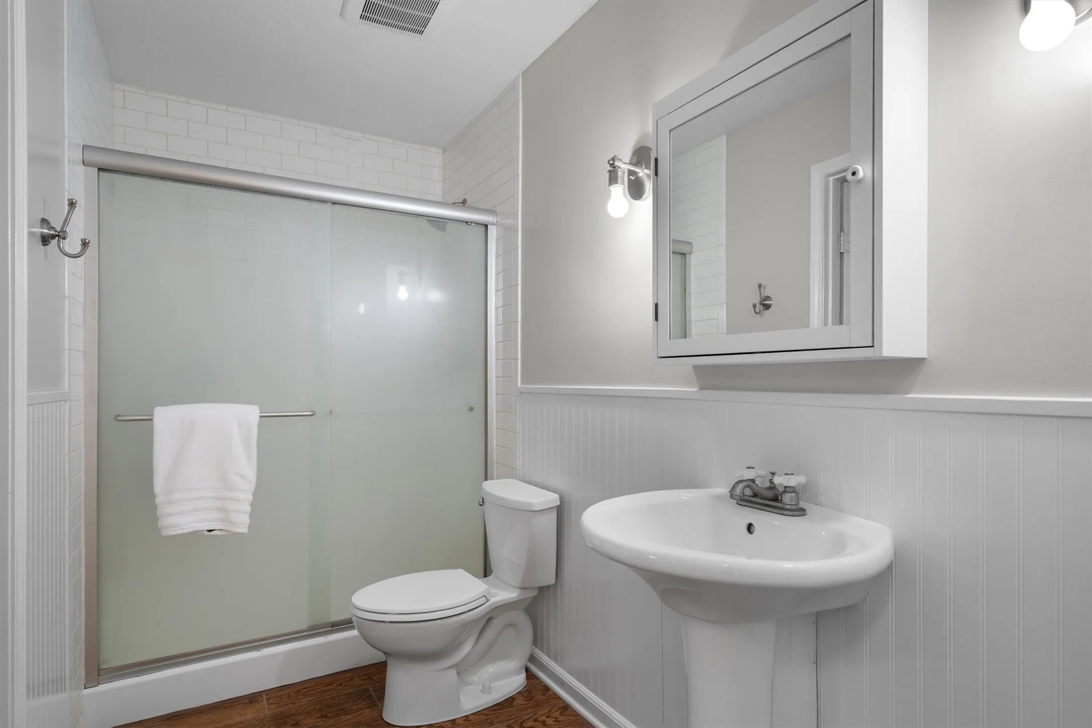 Full bathroom with walk-in shower, pedestal sink, and updated fixtures