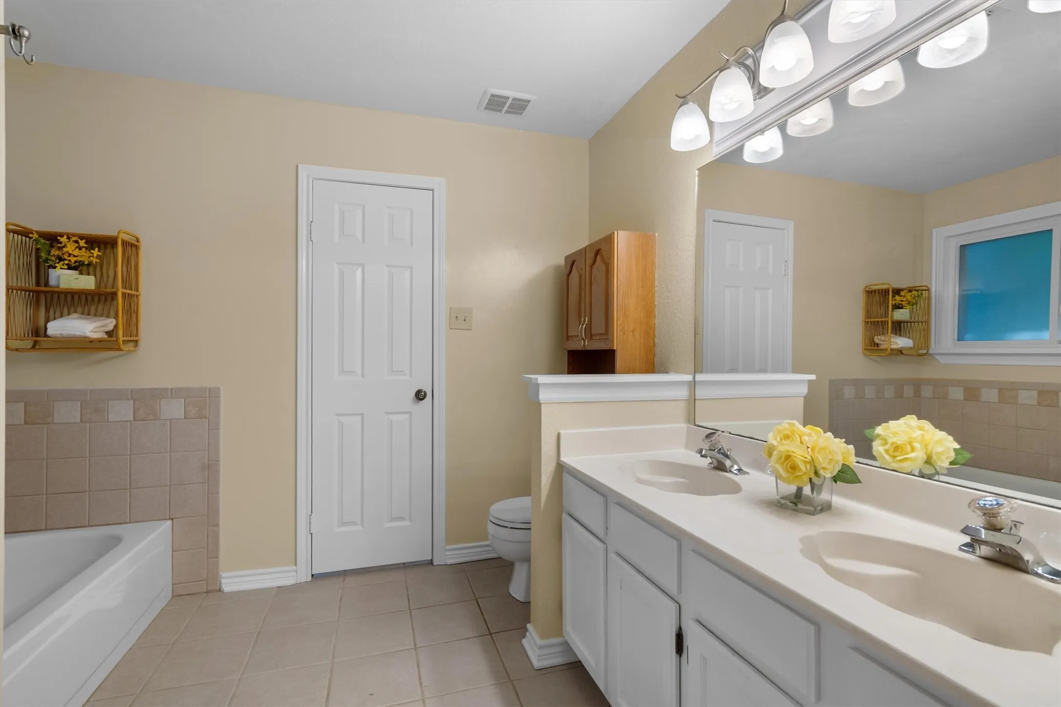 Spa-style primary bath with dual vanity, garden soaking tub, and separate walk-in shower