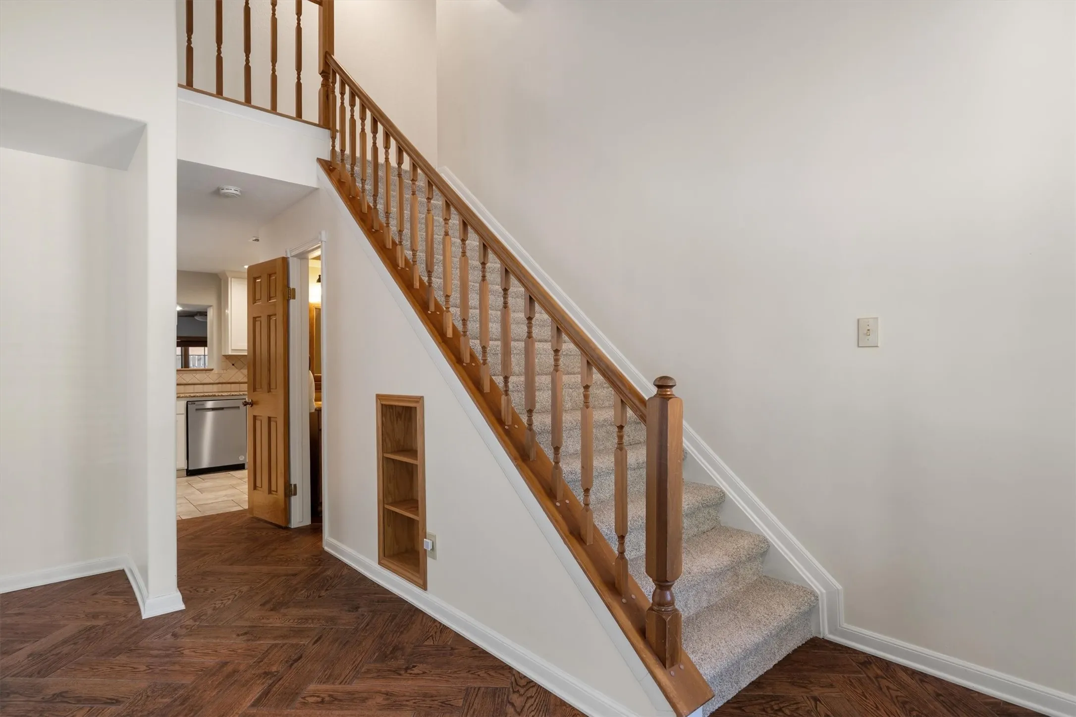 Staircase landing with wood flooring and detailed railing