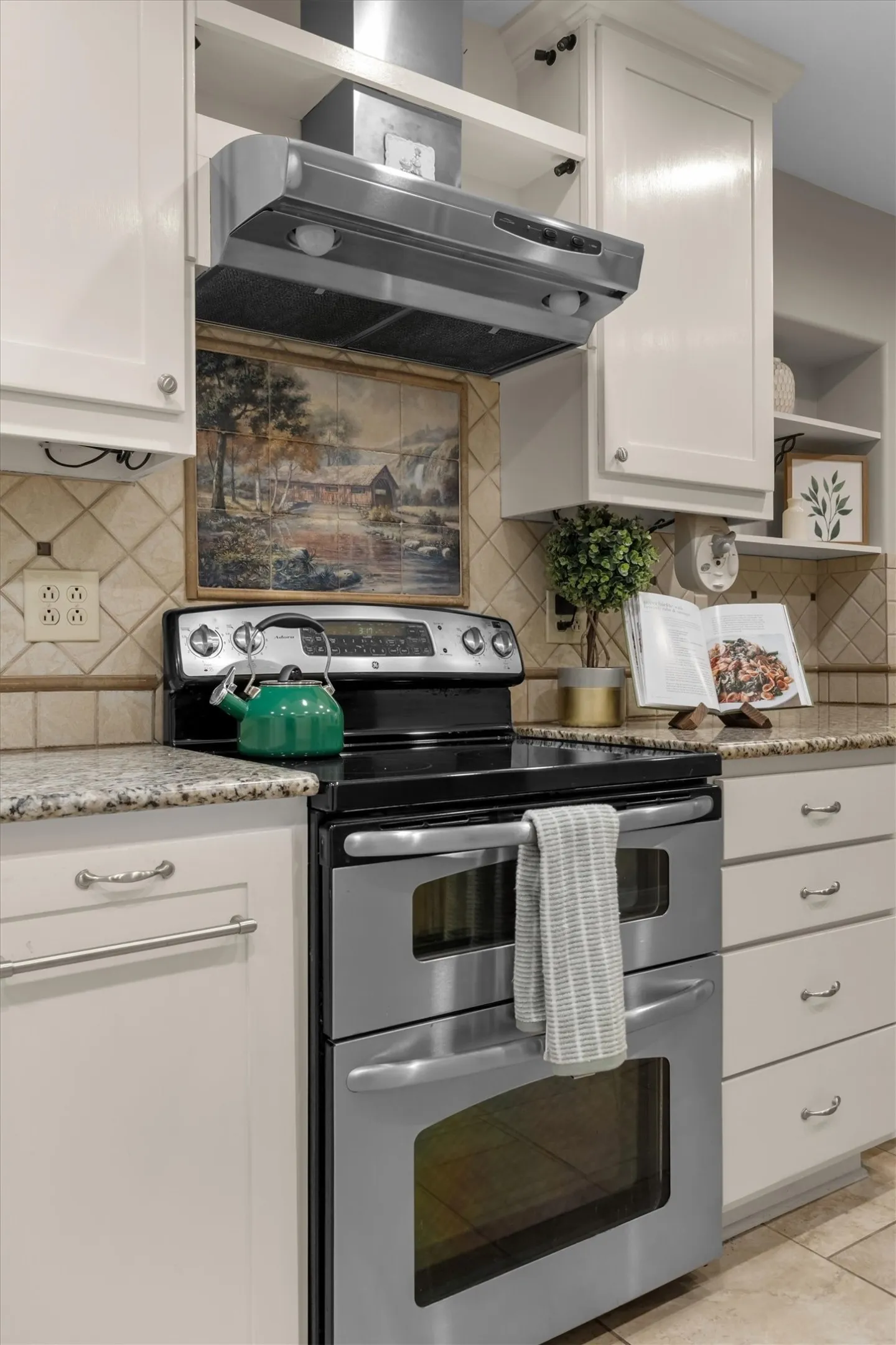 Close-up of the chef-ready range and vent hood with tile backsplash detail