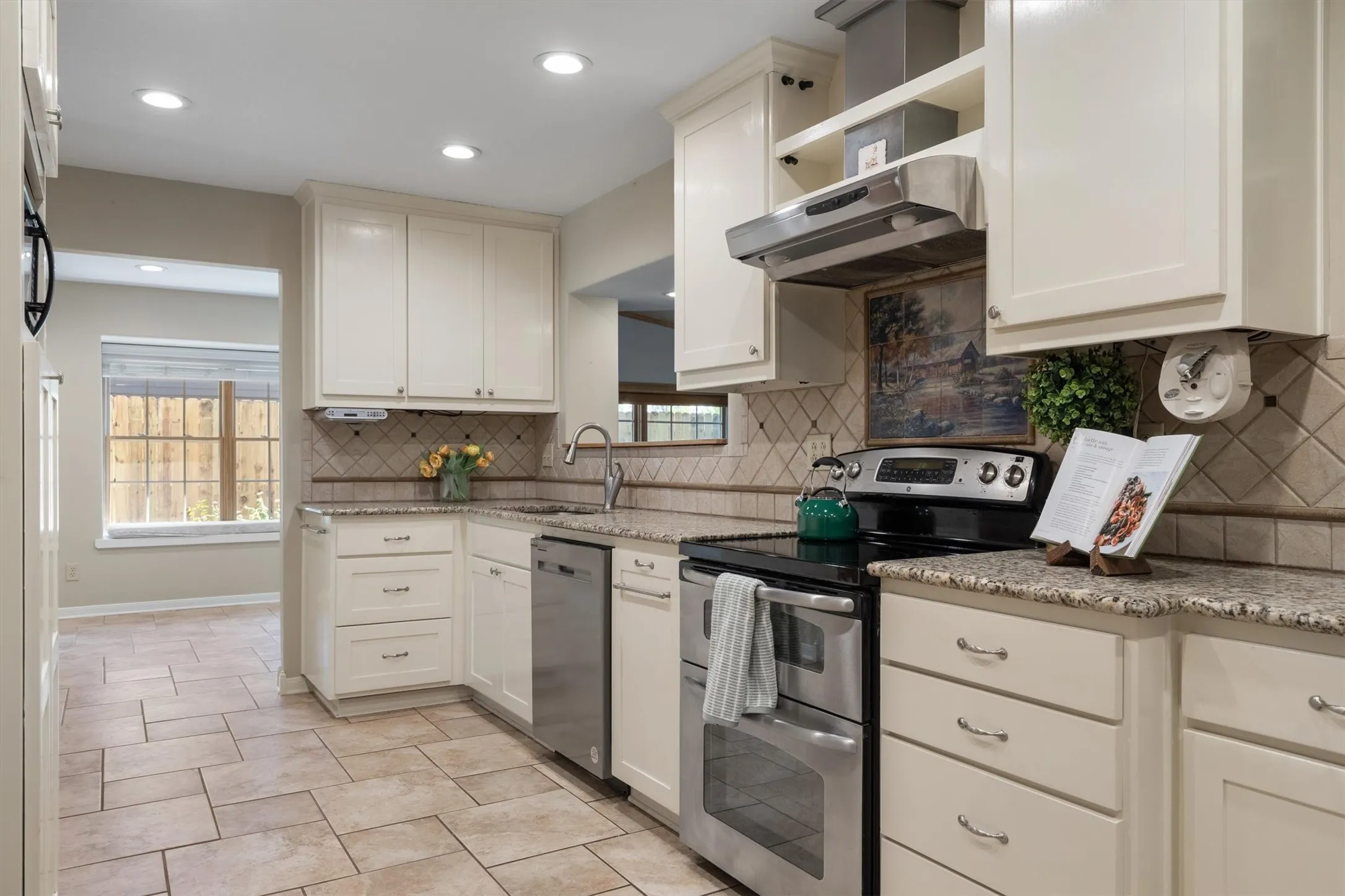 Kitchen showcasing granite countertops, tile flooring, and abundant white cabinetry