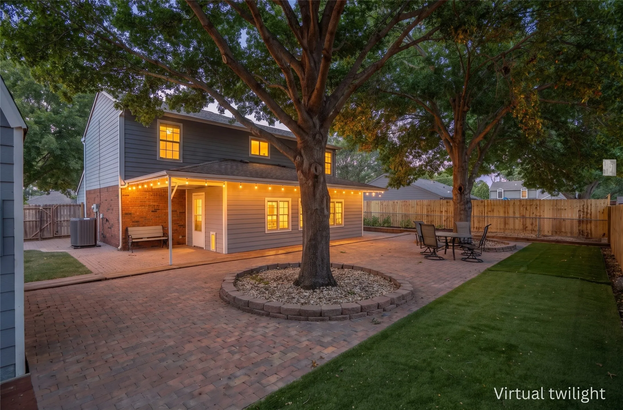 Expansive backyard with mature shade trees and a string-lit patio, perfect for entertaining