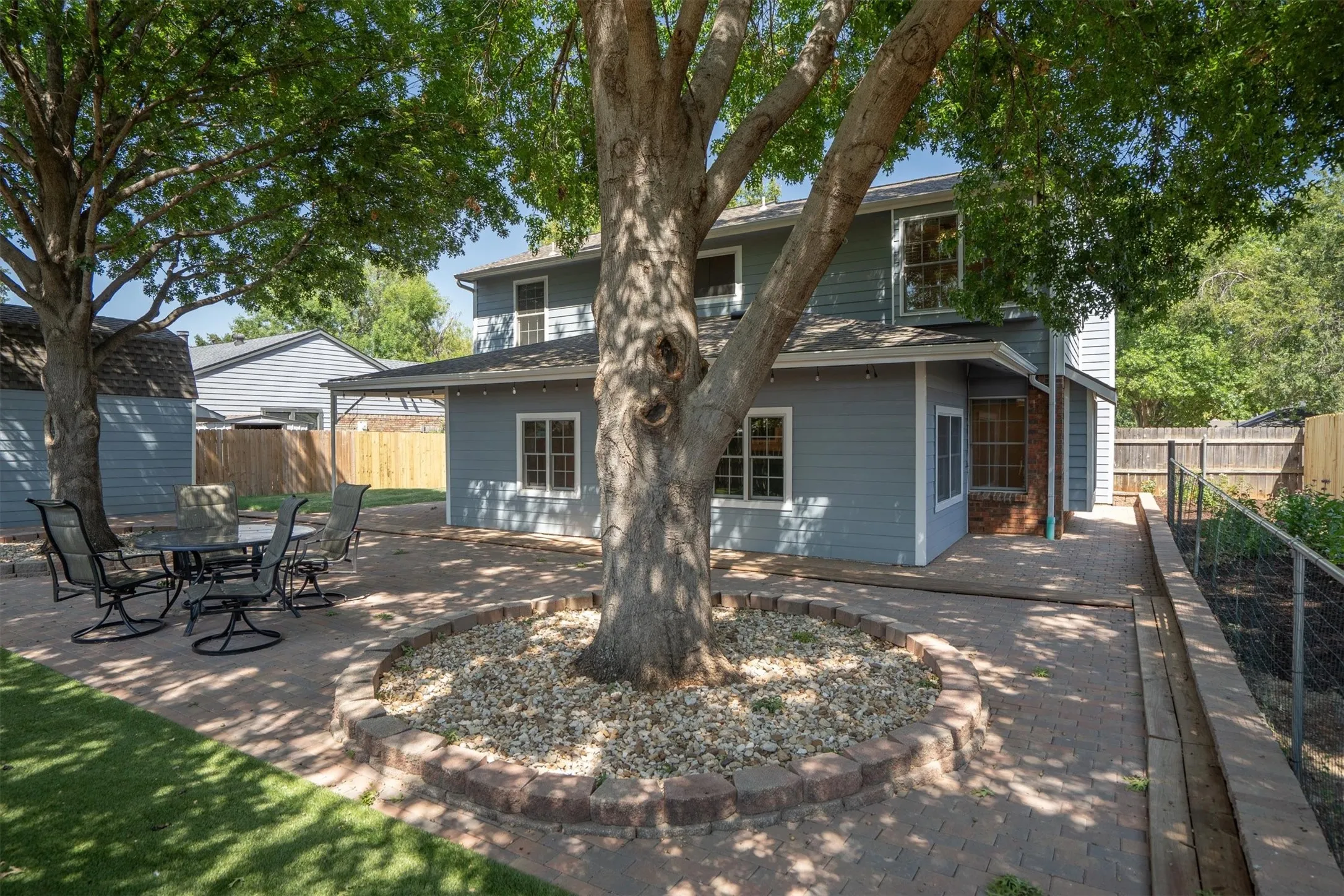Additional backyard view highlighting the spacious patio and seating area