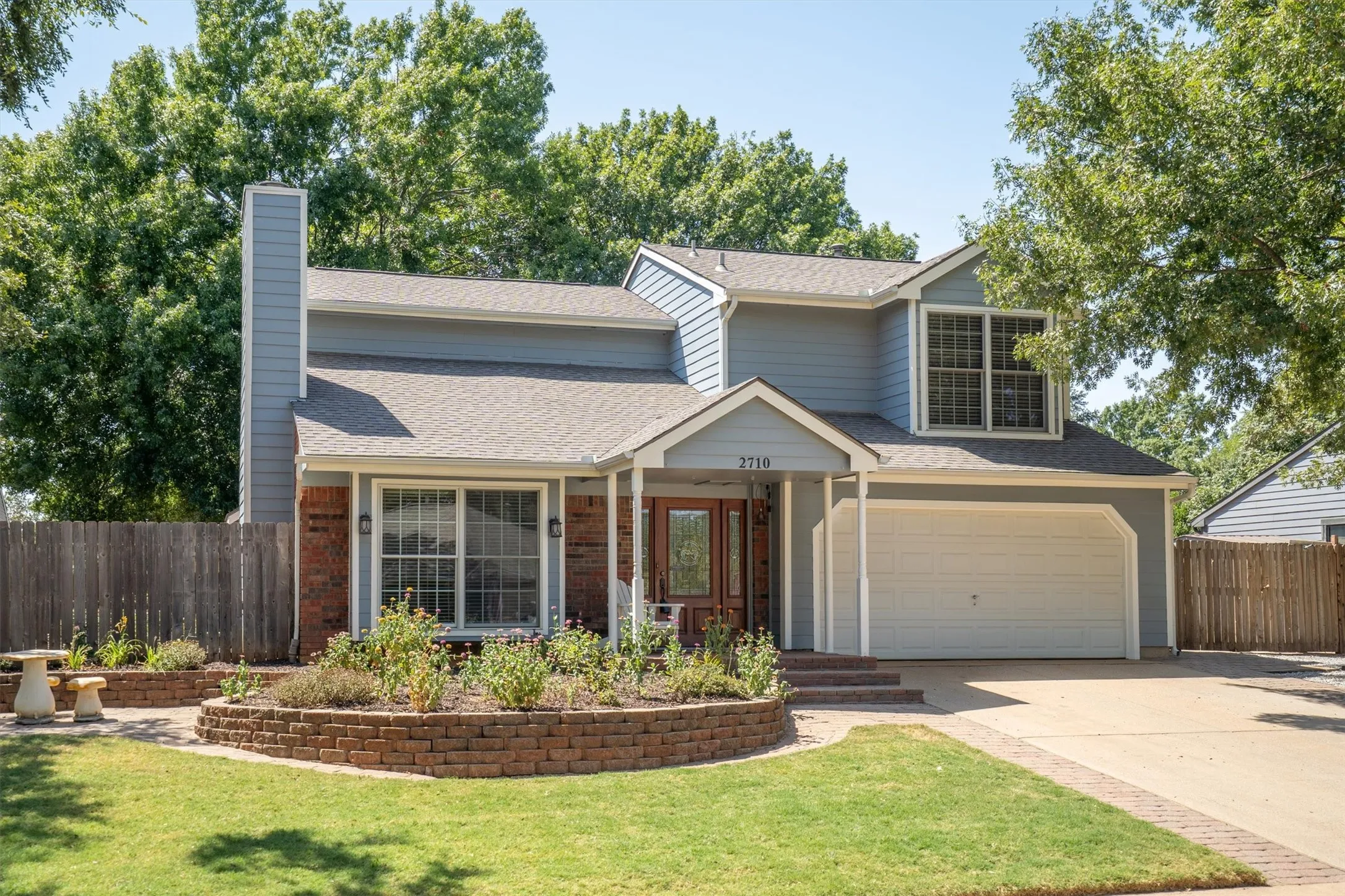 Wide-angle exterior view showcasing manicured landscaping and a spacious front lawn
