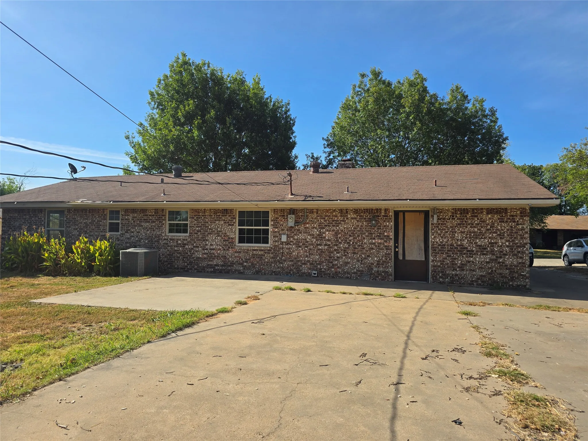 Brick exterior with a brown shingle roof