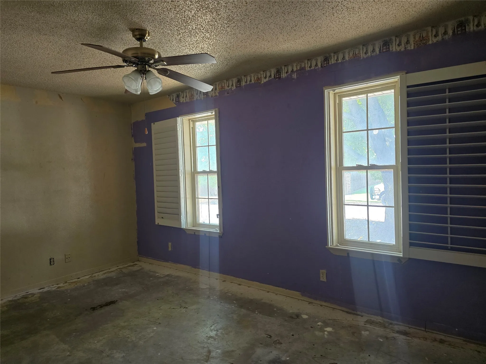 Ceiling fan with integrated lighting, two windows, and interior window shutters