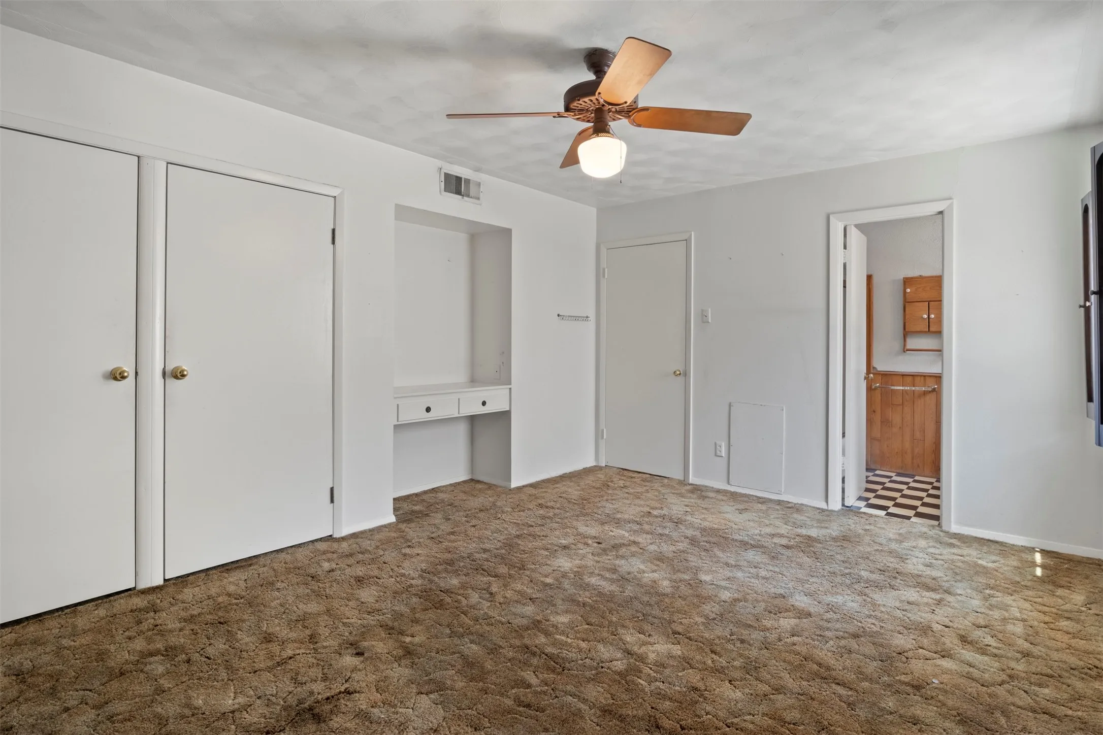 Built-in desk area, dual closets, and ceiling fan with integrated lighting