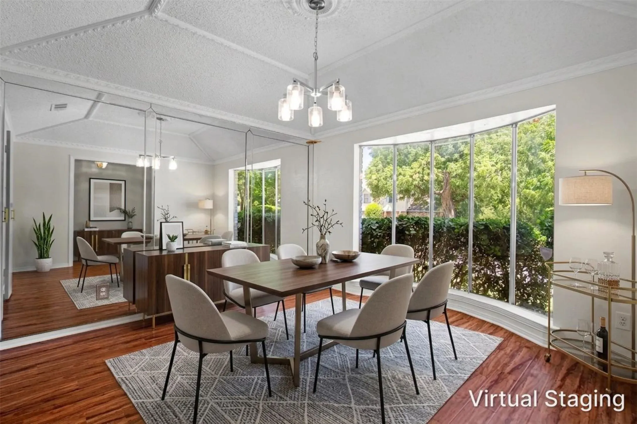 Hardwood-finish flooring, a decorative ceiling with crown molding, a bay window, and mirrored wall accents