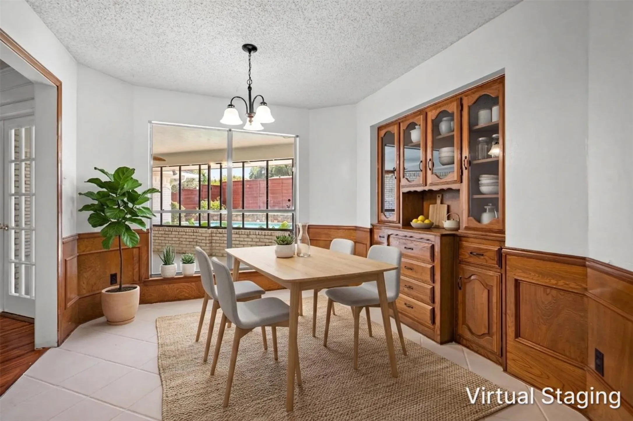 Built-in wood cabinetry with glass fronts, wood paneling, tiled flooring, and a large bay window