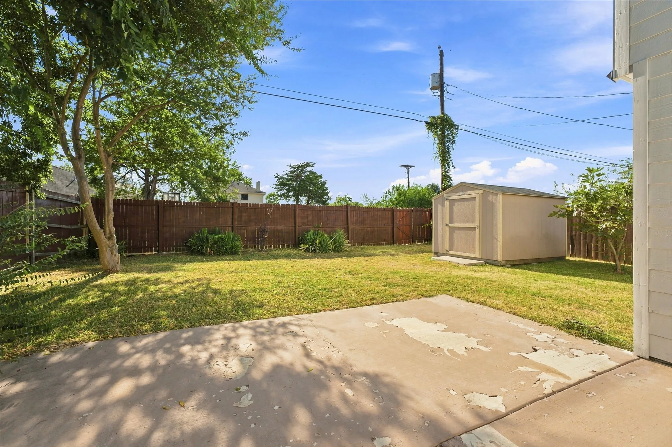 Spacious backyard with a wood fence, offering a comfortable outdoor space for relaxing, entertaining, and enjoying the fresh air.