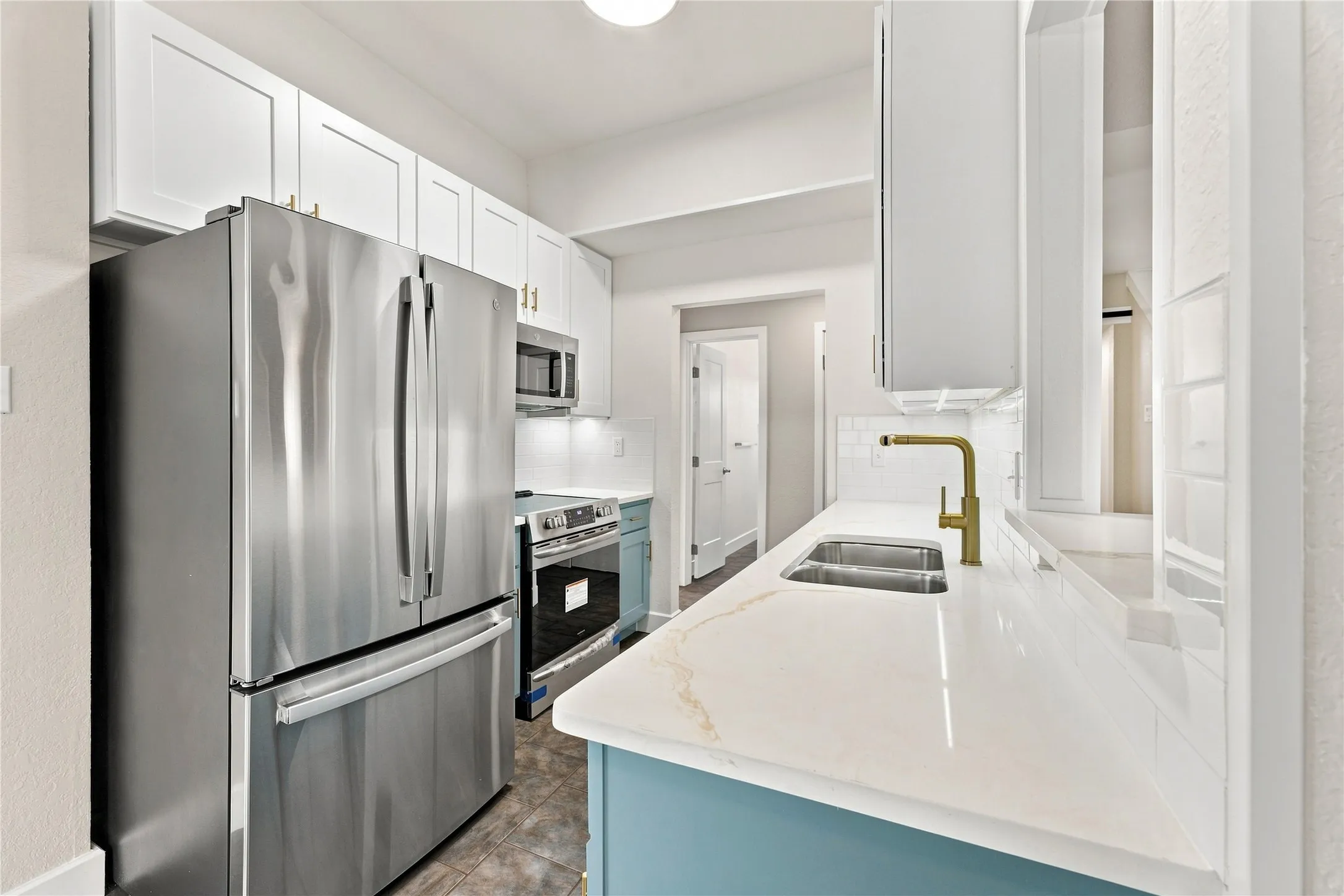 Remodeled kitchen featuring elegant quartz countertops, soft-close cabinetry, and brand-new appliances for a modern, move-in-ready finish.