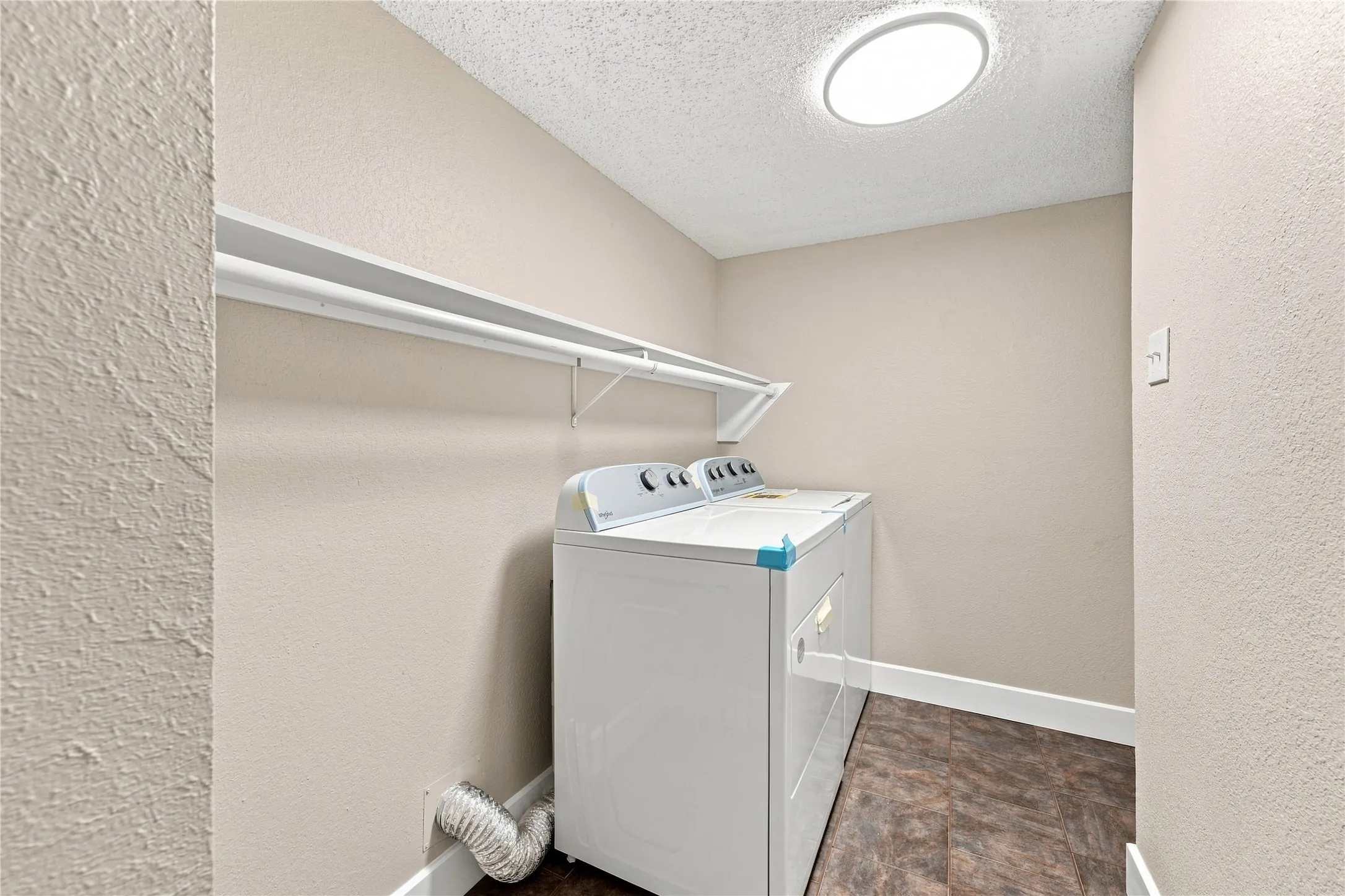 Updated laundry room featuring brand-new appliances and a clean, functional layout.