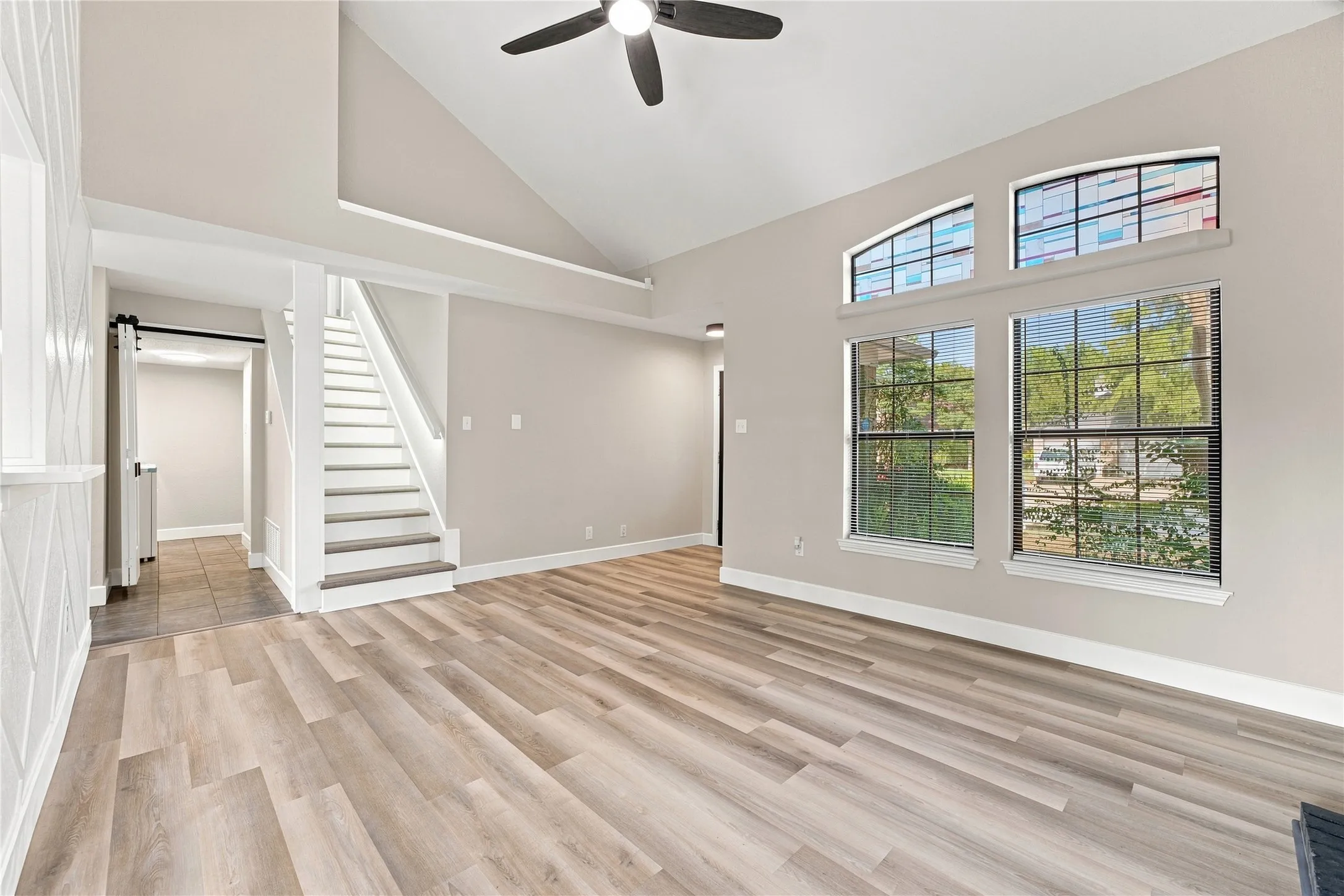 Spacious and bright living room showcasing the staircase and upgraded luxury LED lighting!
