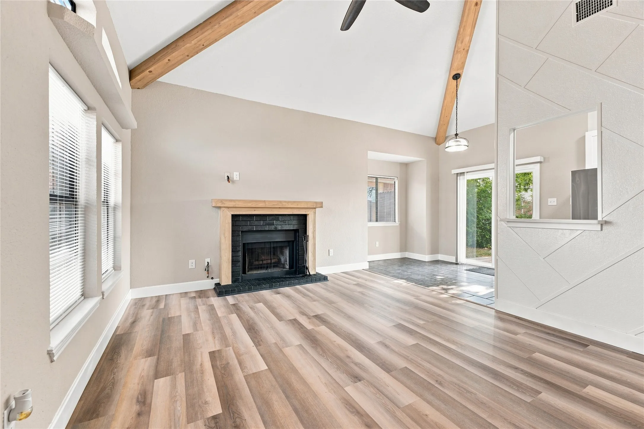 pacious living room featuring vaulted ceilings, a cozy fireplace, and an open, inviting atmosphere.