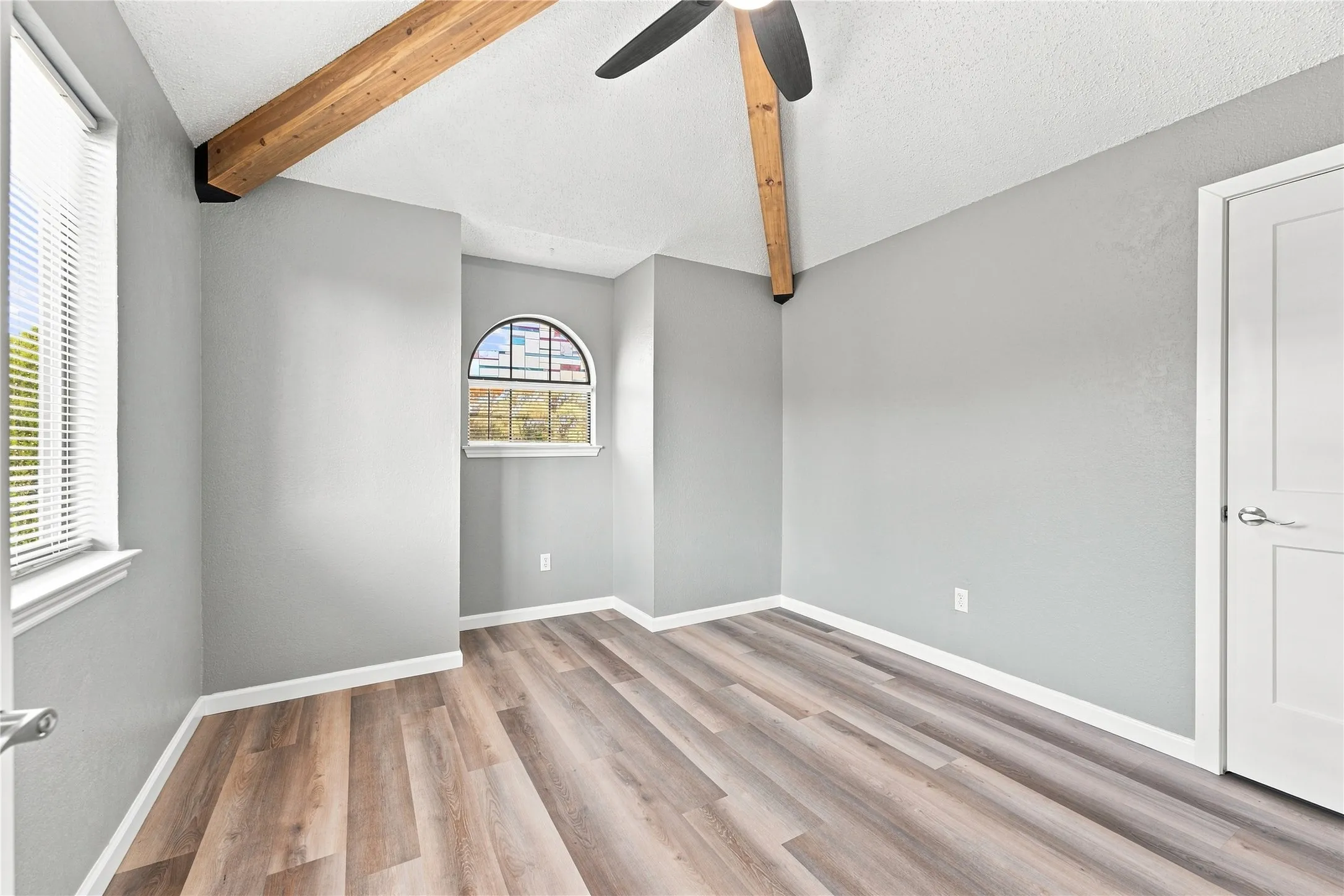 Spacious upstairs bedroom featuring vaulted ceilings, creating an open and airy feel.