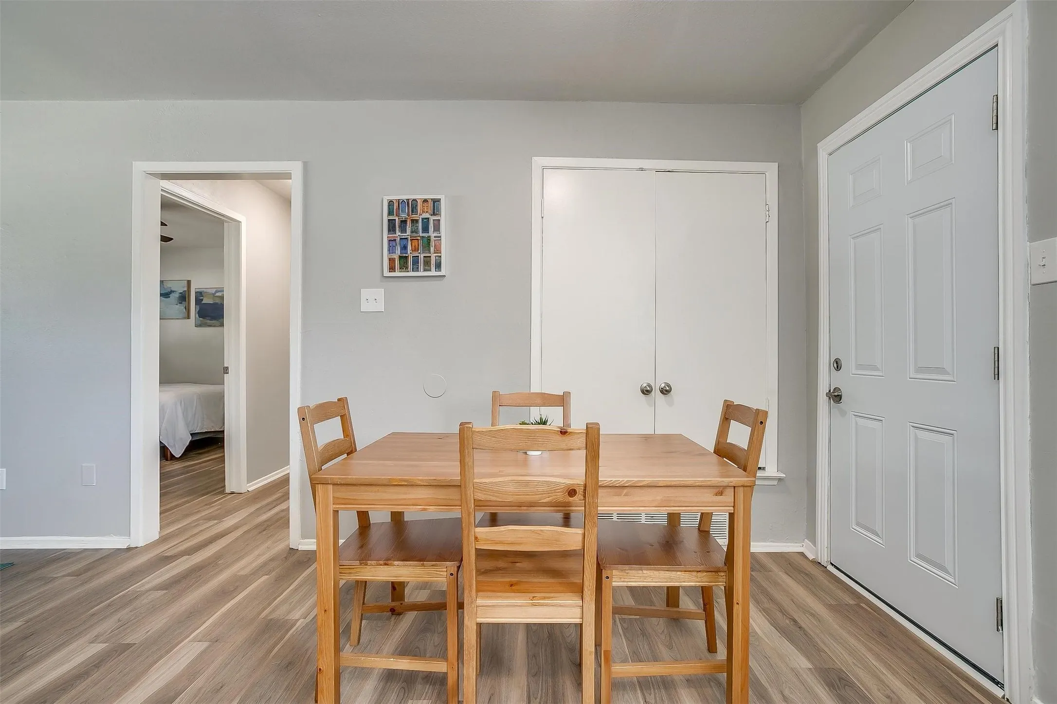 Bright interior featuring wood-finish flooring, light gray wall paint, and white trim