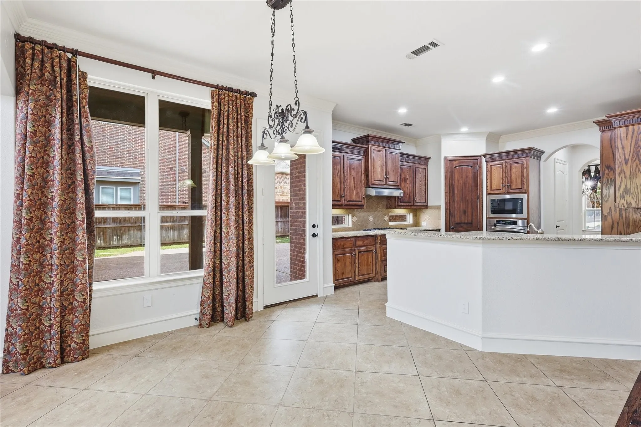 Kitchen featuring wood cabinetry, stainless steel appliances, and a pass-through counter