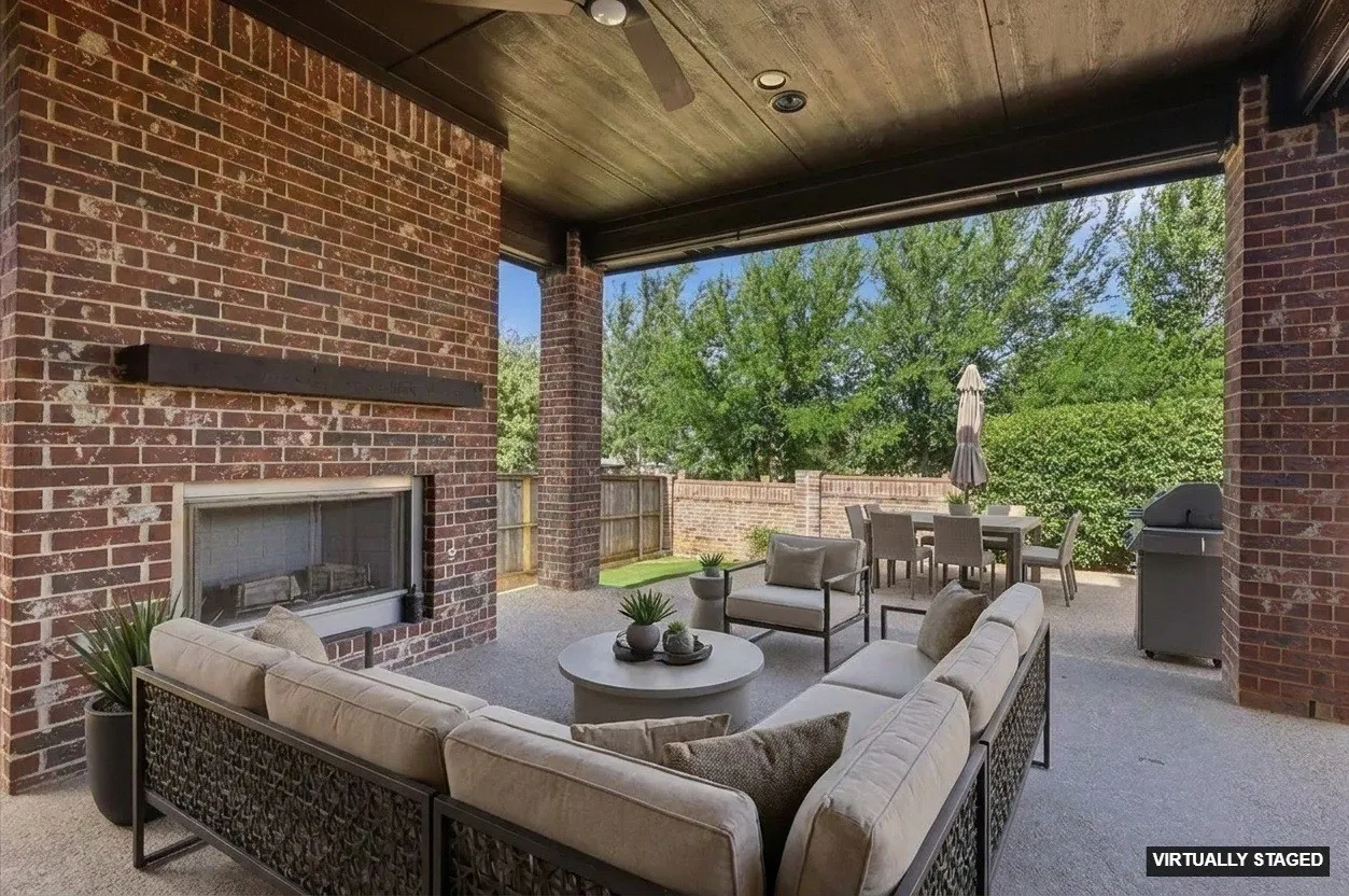 Covered patio featuring a brick fireplace with a mantle, ceiling fan, and recessed lighting