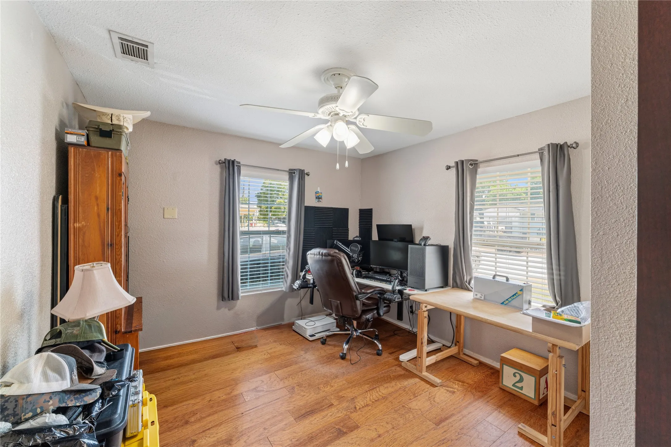 Wood-finish flooring, ceiling fan, and window with blinds