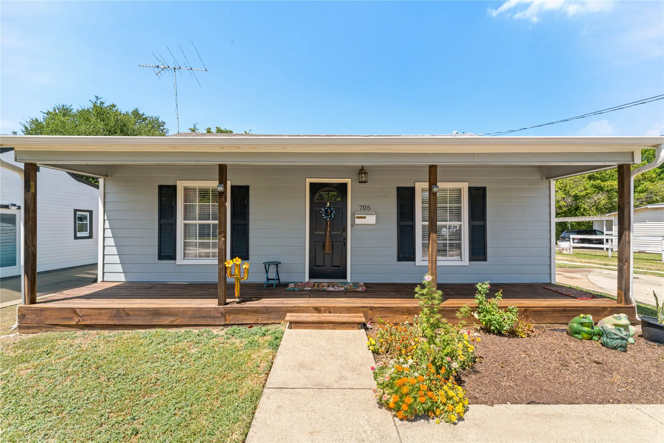 Light blue siding exterior with a covered wood-deck porch