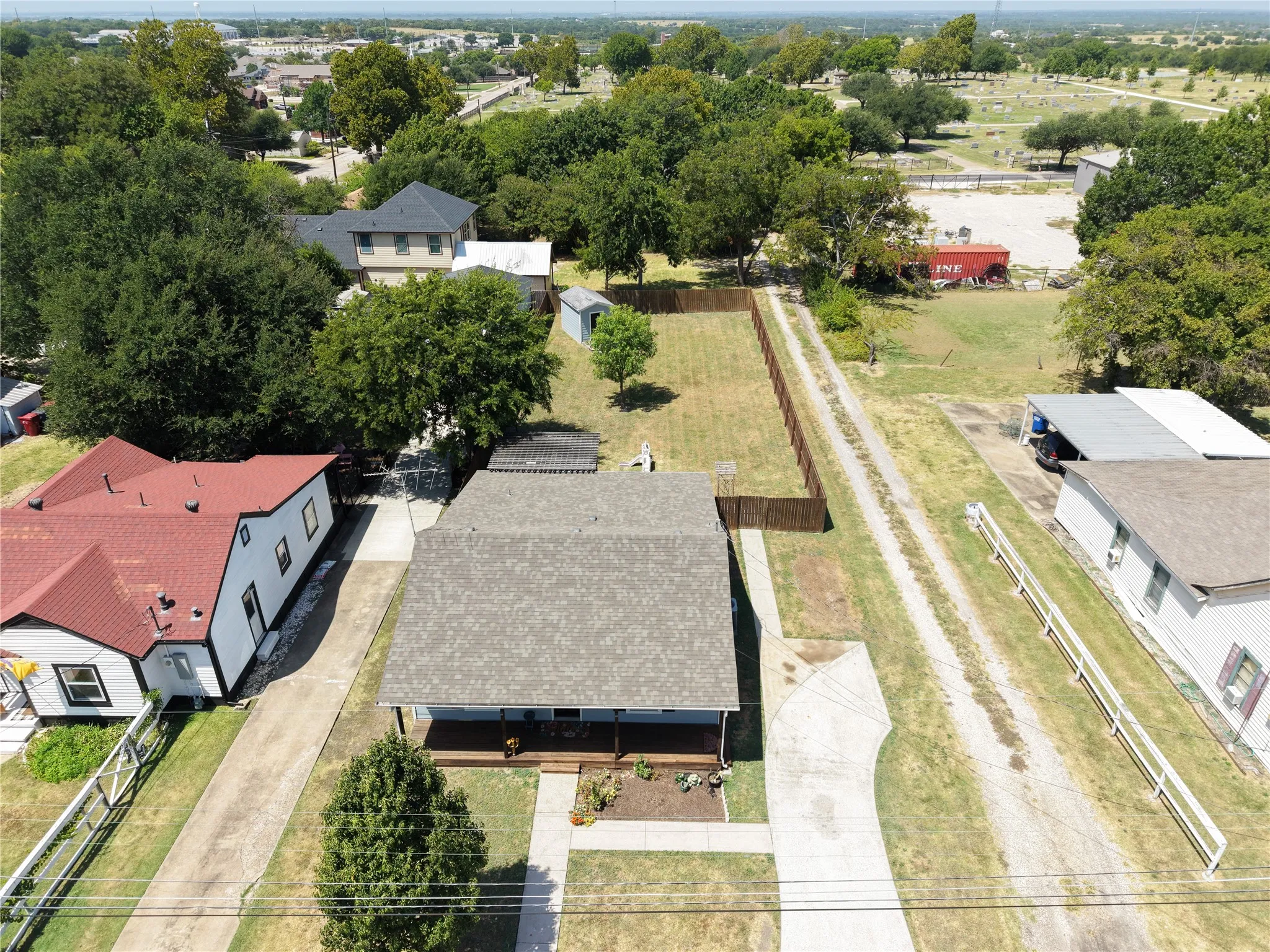 Aerial view showcasing a multi-building rural property with expansive grounds, mature tree-lined landscape, and established driveway access