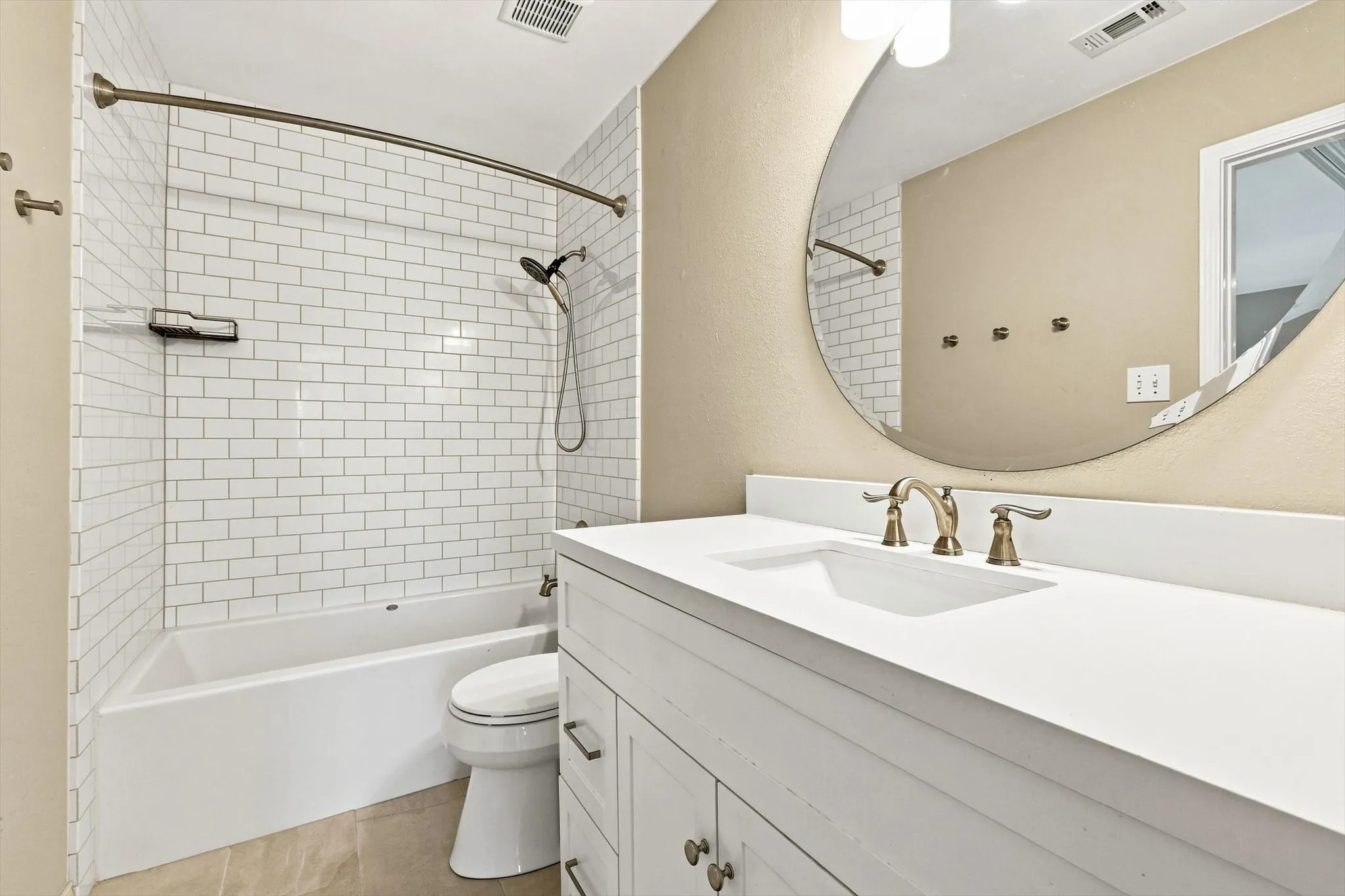 White subway tile shower surround with integrated tub and handheld shower fixture