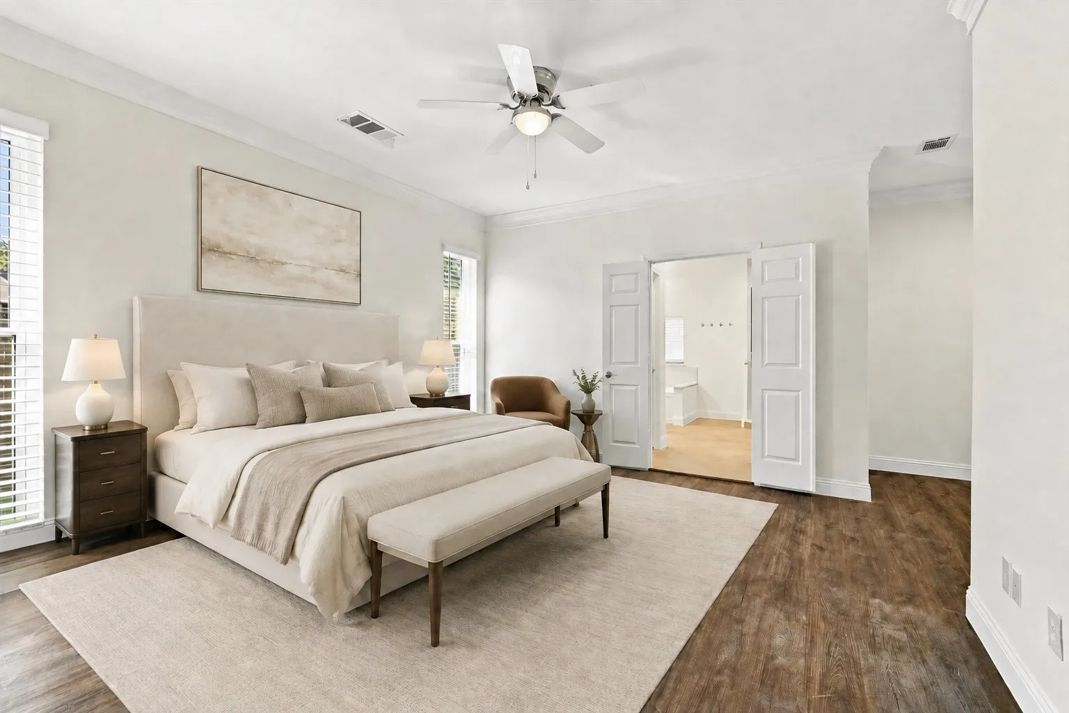 Wood-finish flooring with an area rug, white walls, and crown molding