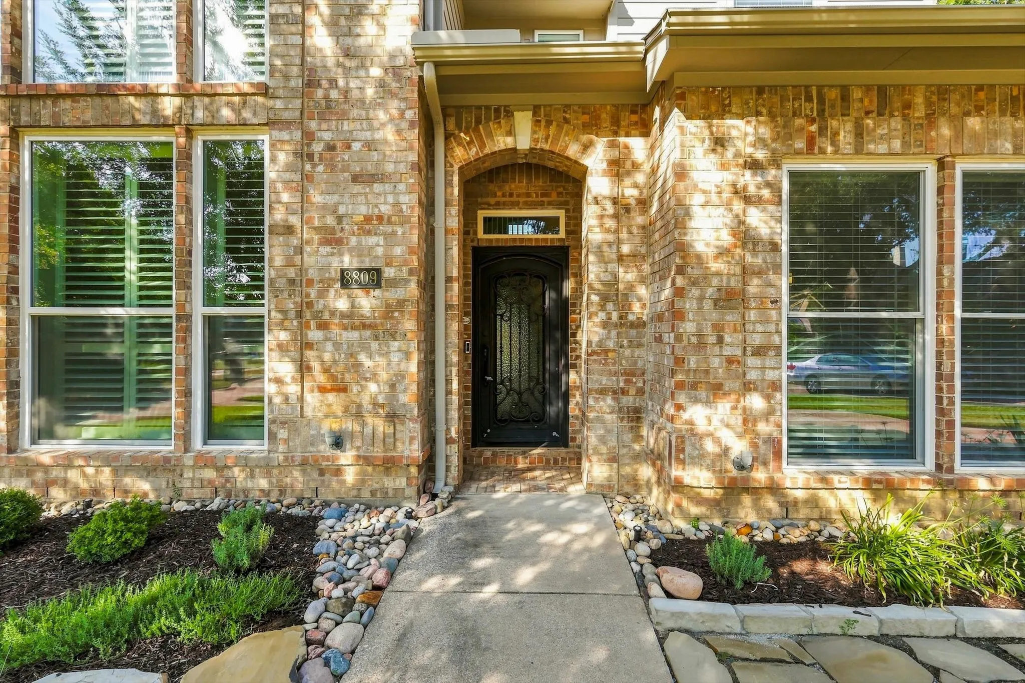Front arched entryway, with an ornate wrought iron door