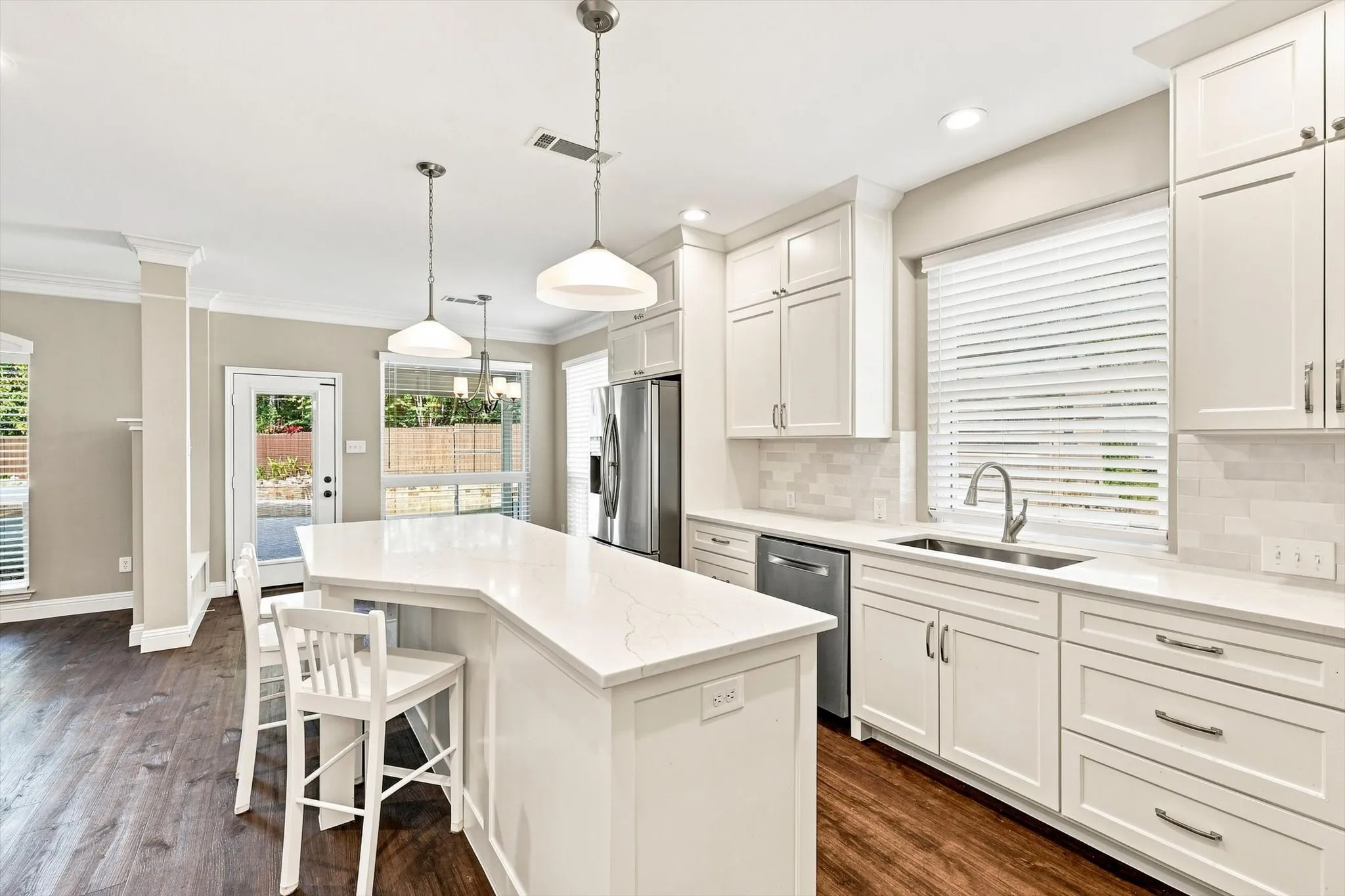 Kitchen featuring white cabinetry, light-colored countertops, stainless steel appliances, and wood-finish flooring