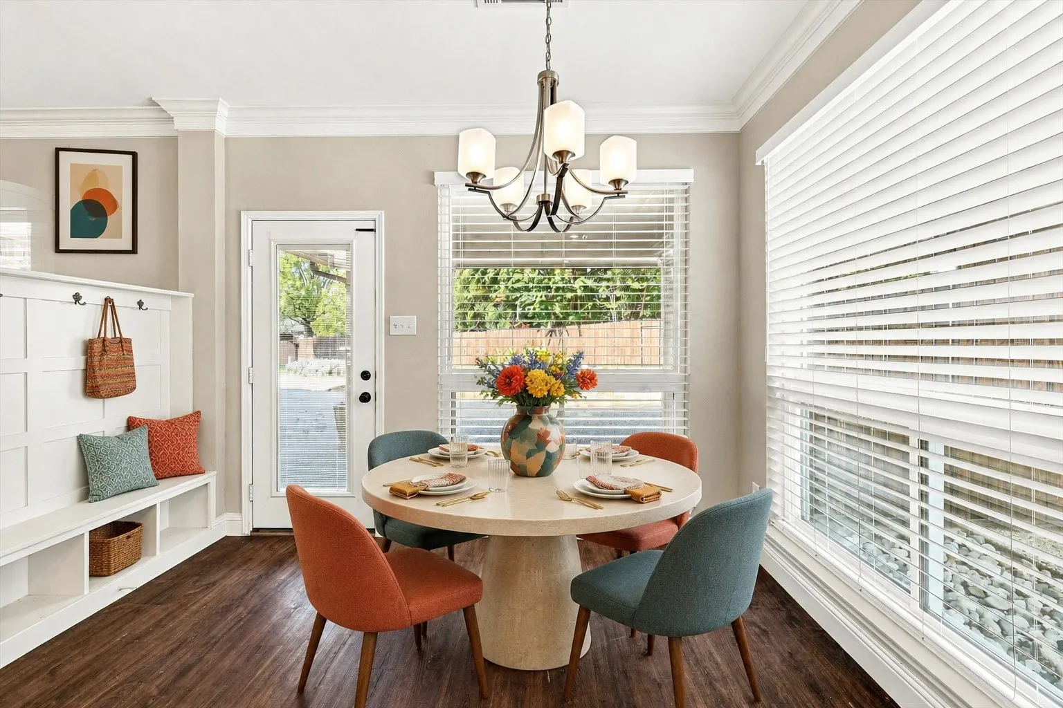 Virtual Staged Built-in hall tree with storage, wood-finish flooring, multiple windows with blinds, glass-paneled door, and crown molding