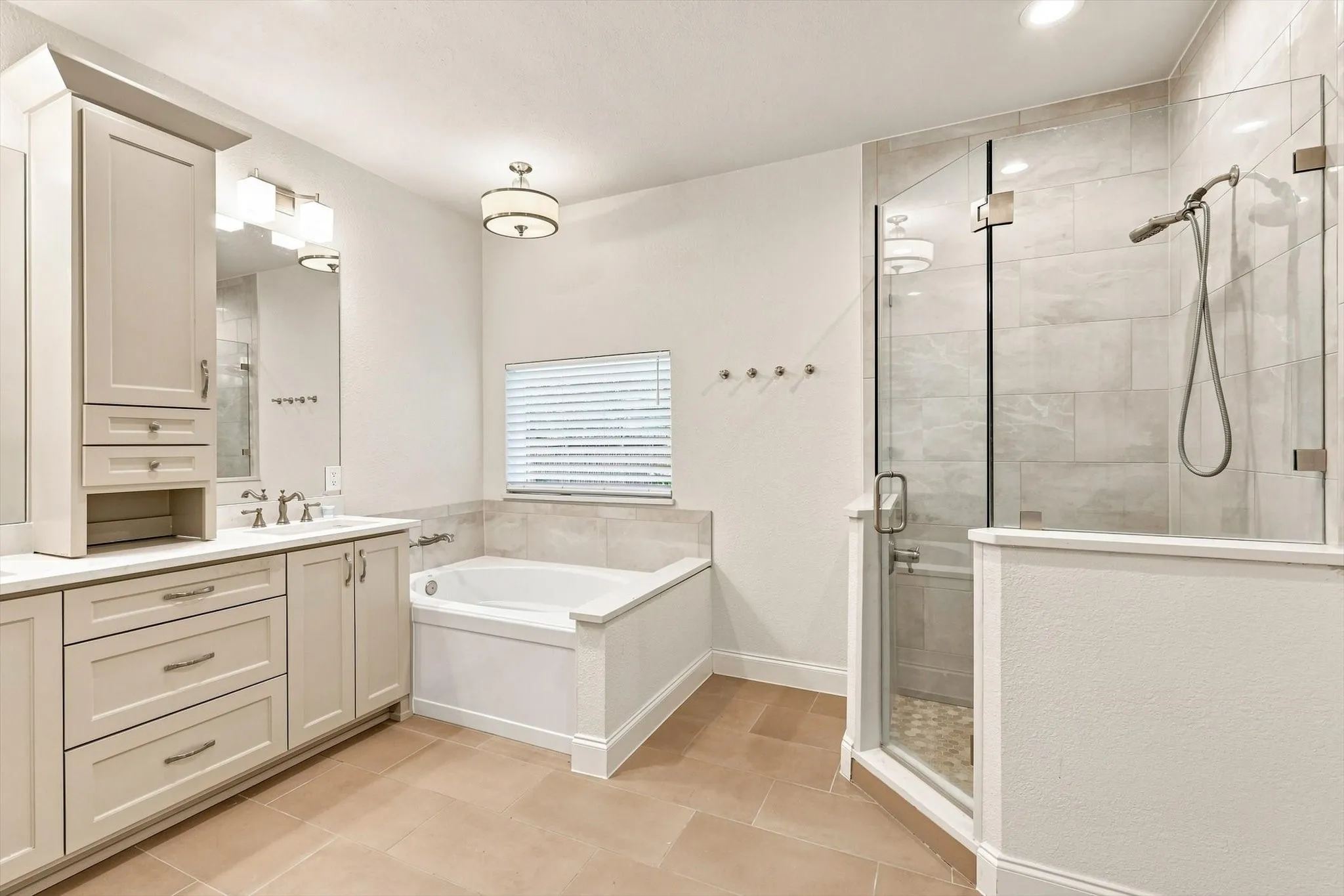 Dual sink vanity with light-toned cabinetry and solid surface countertops