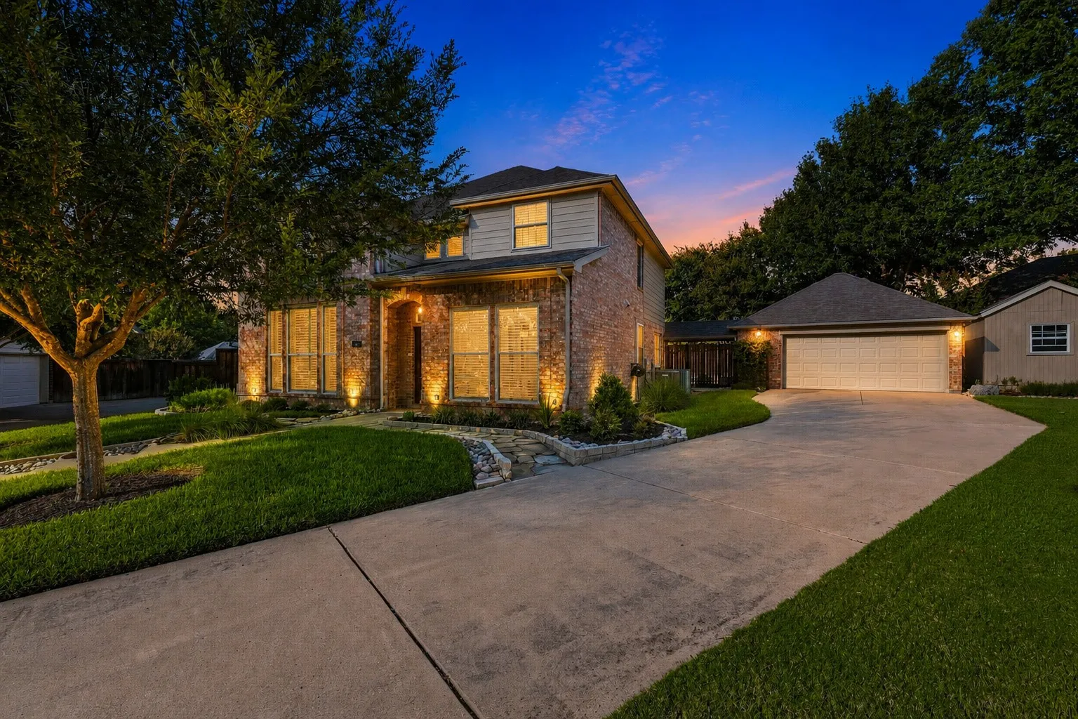 Brick and siding exterior with a gabled roof, 2 car garage and spacious shed